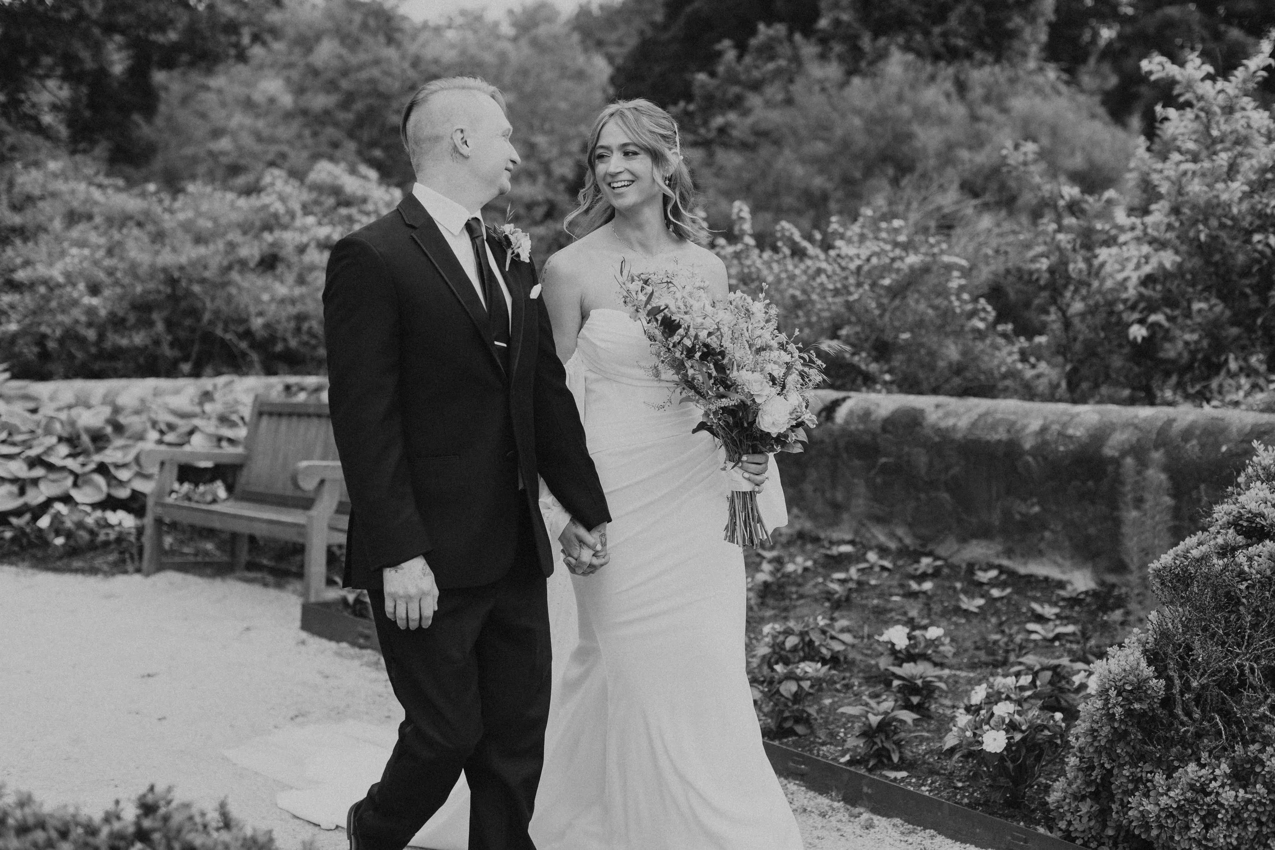 bridal couple walking and smiling at each other after wedding ceremony