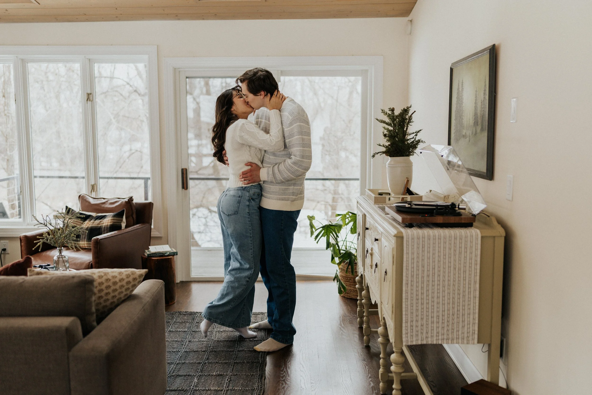 young couple kissing in living room of beautiful house