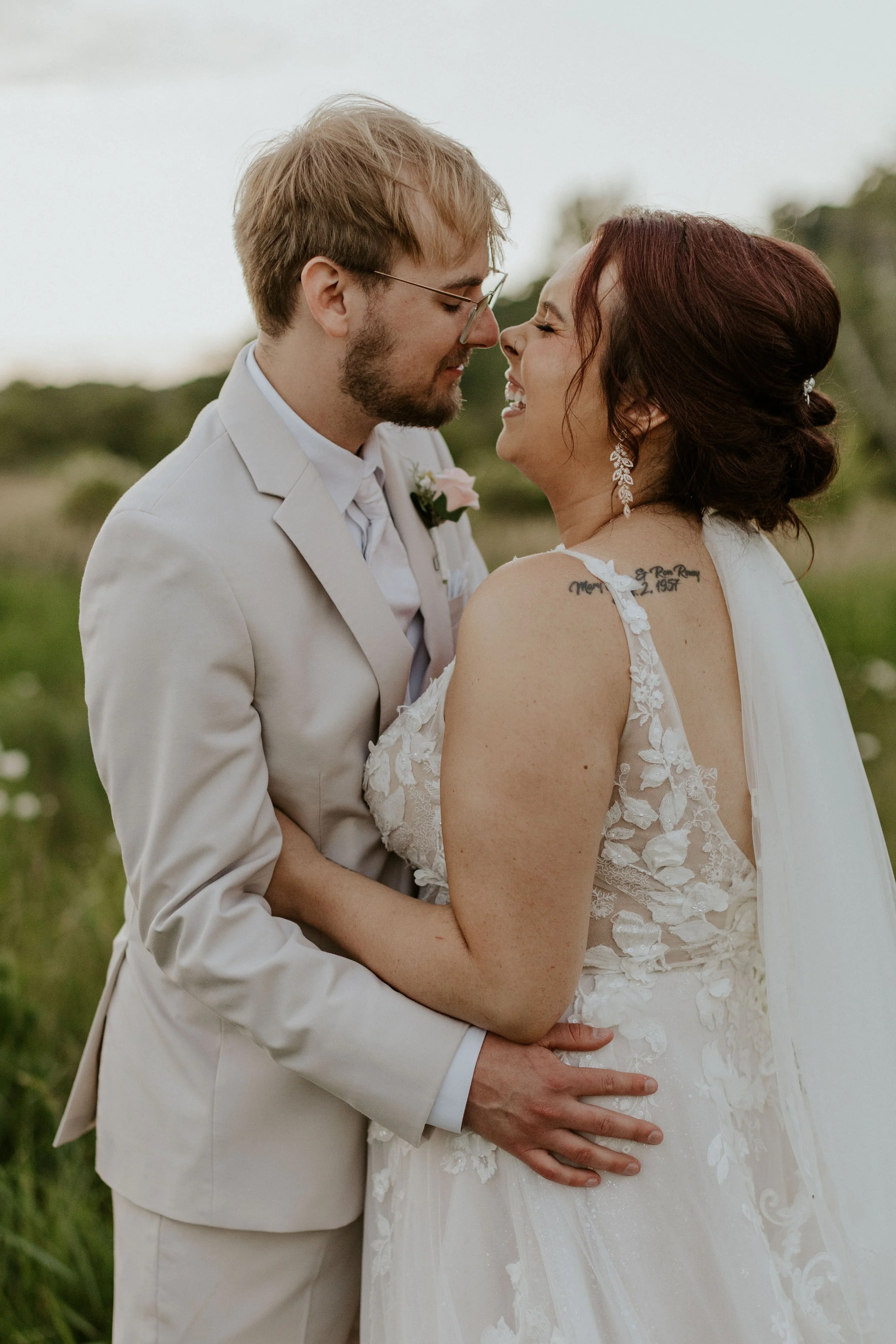 bridal couple embracing and laughing going in for a kiss