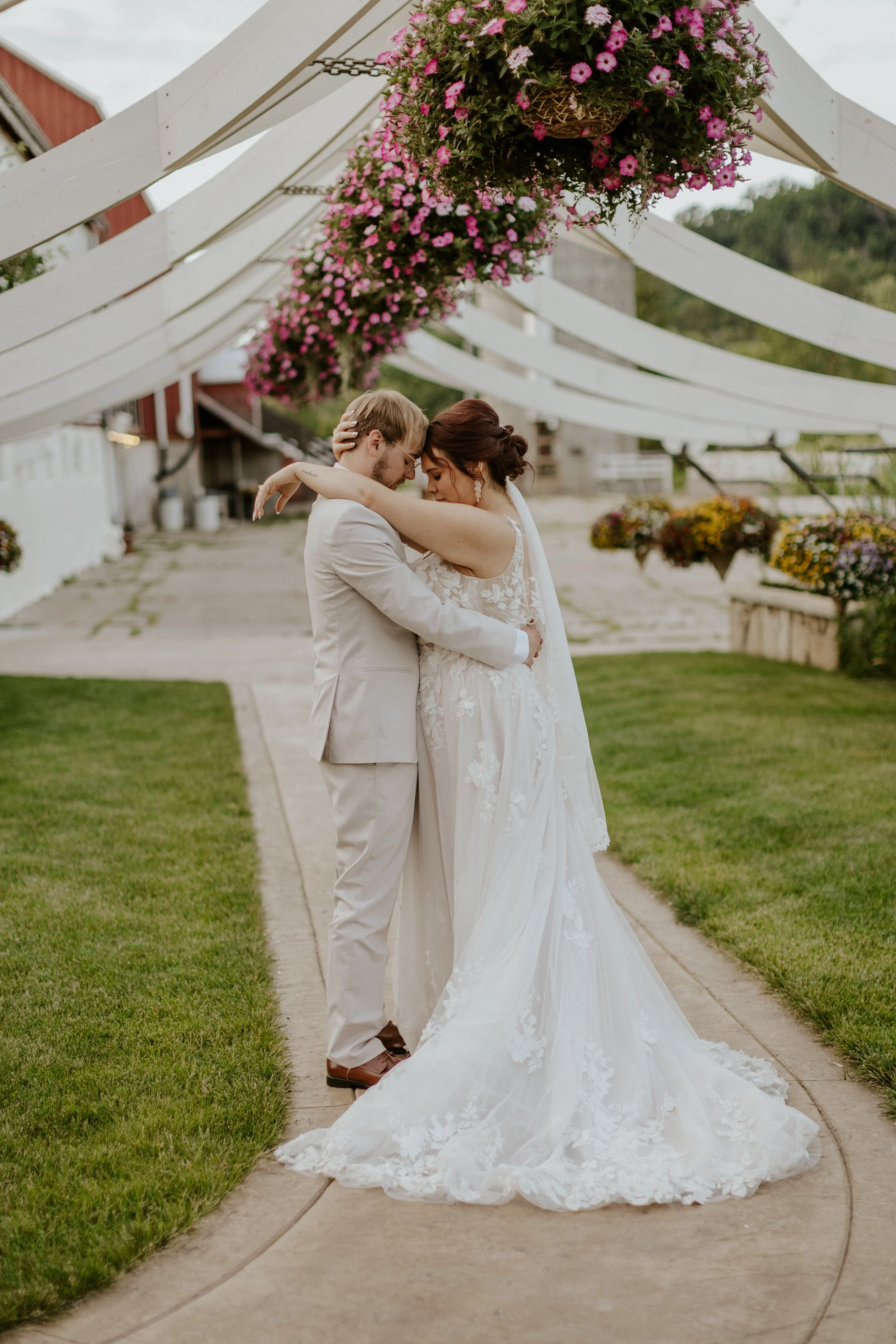 bridal couple embracing under floral arch