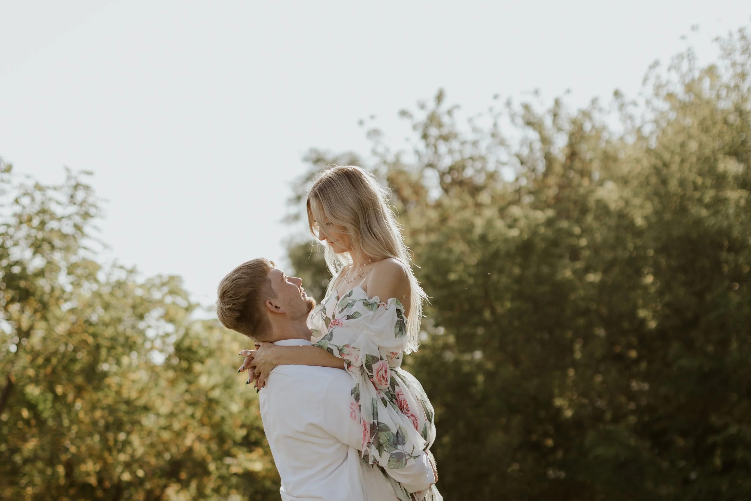 groom picking up bride and spinner her in a field in Fort Collins