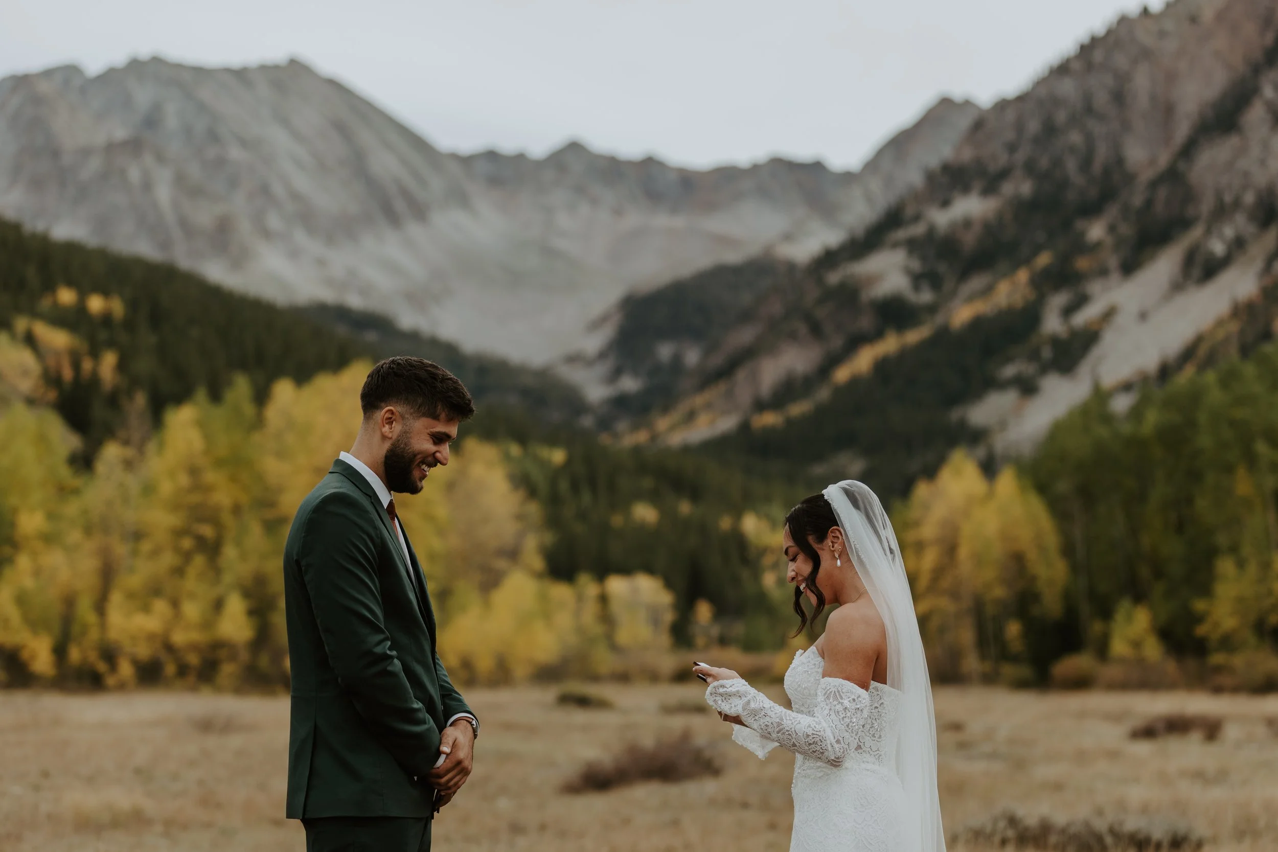 young bridal couple reading vows during colorado mountain ceremony