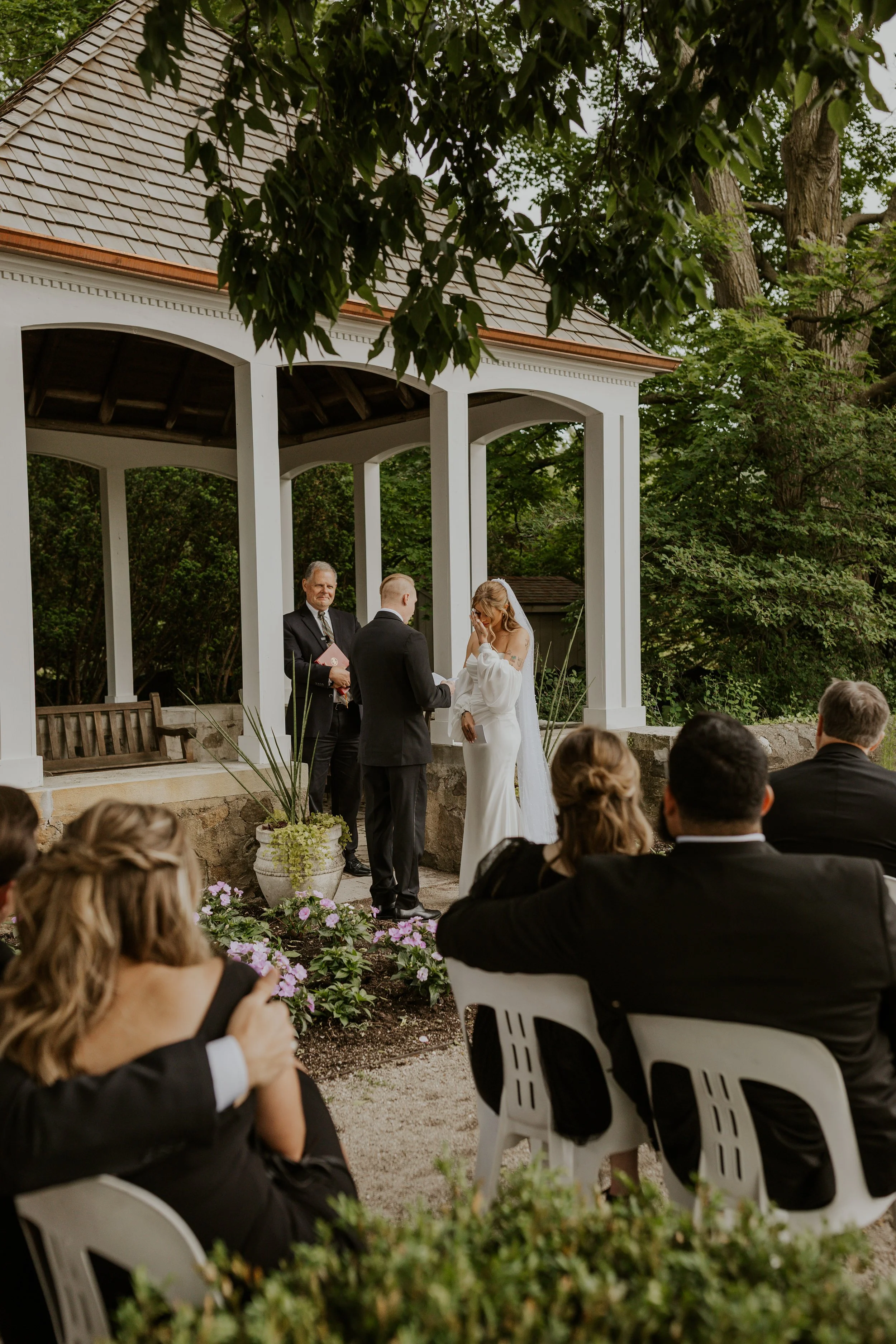 bride crying while groom reads vows during intimate ceremony