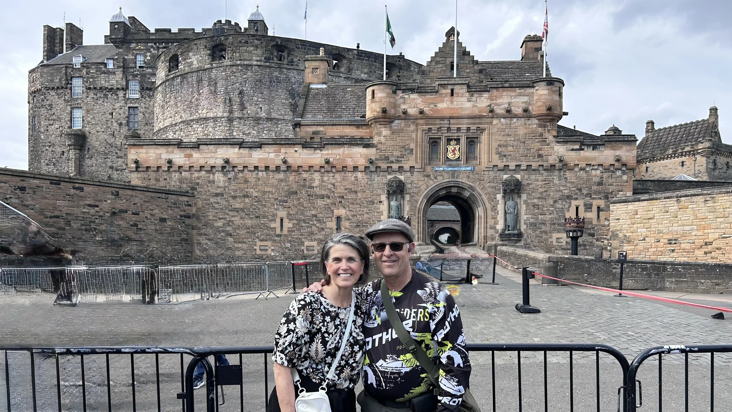 Tami and her husband in front of a castle in Scotland