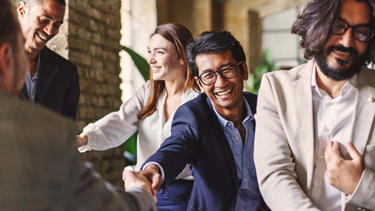 Group of smiling people shaking hands