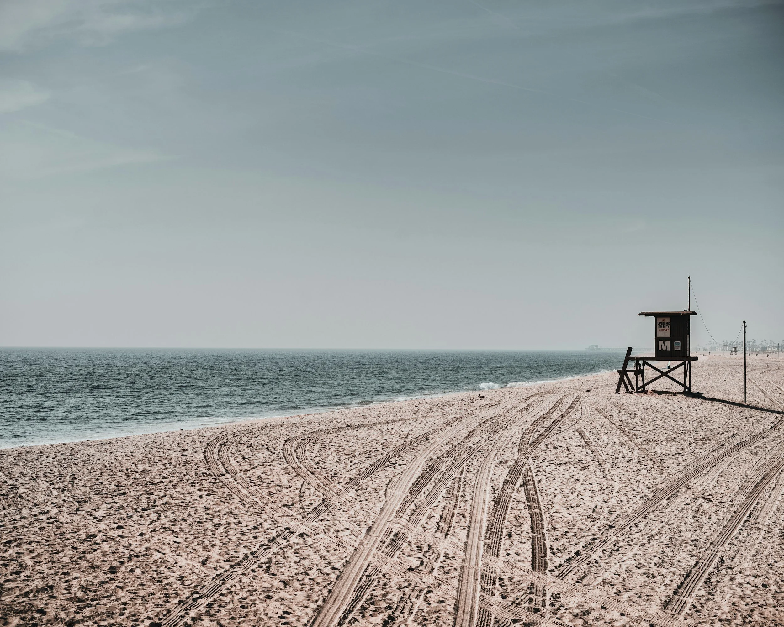 Modern chandelier with numerous exposed bulbs hanging from wires against a ceiling.