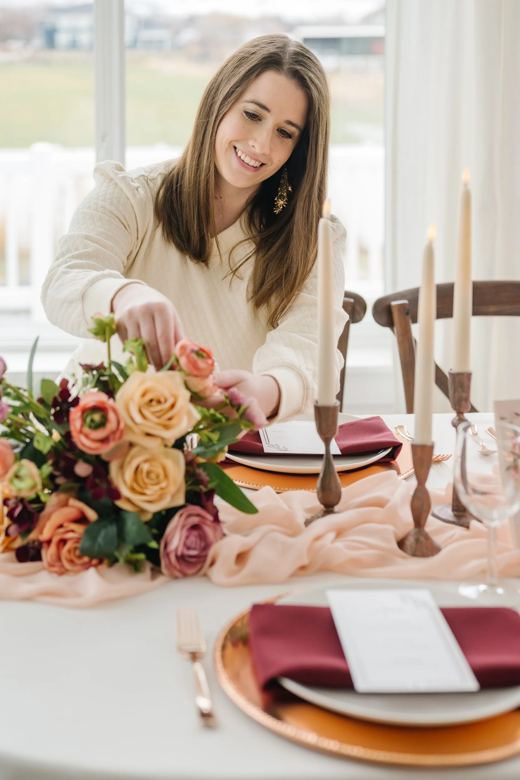 Headshot of Courtney, a  wedding planner in Utah, with Heirloom Weddings & Events, arranging flowers.