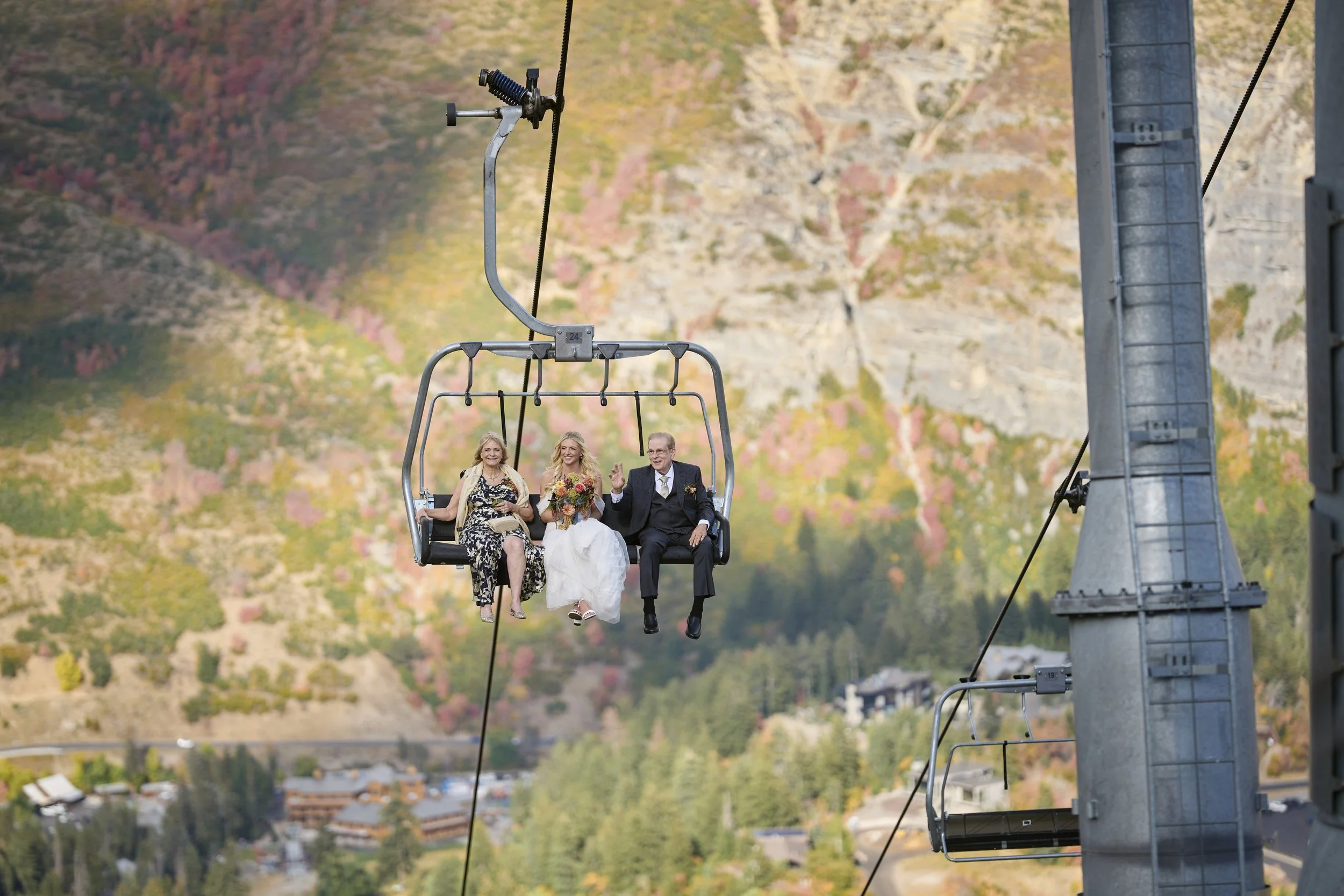 Bride and her partents riding the ski lift to the Mandan Summit at Sundance Resort for her mountain top wedding ceremony planned by Utah wedding planners Heirloom Weddings & Events.