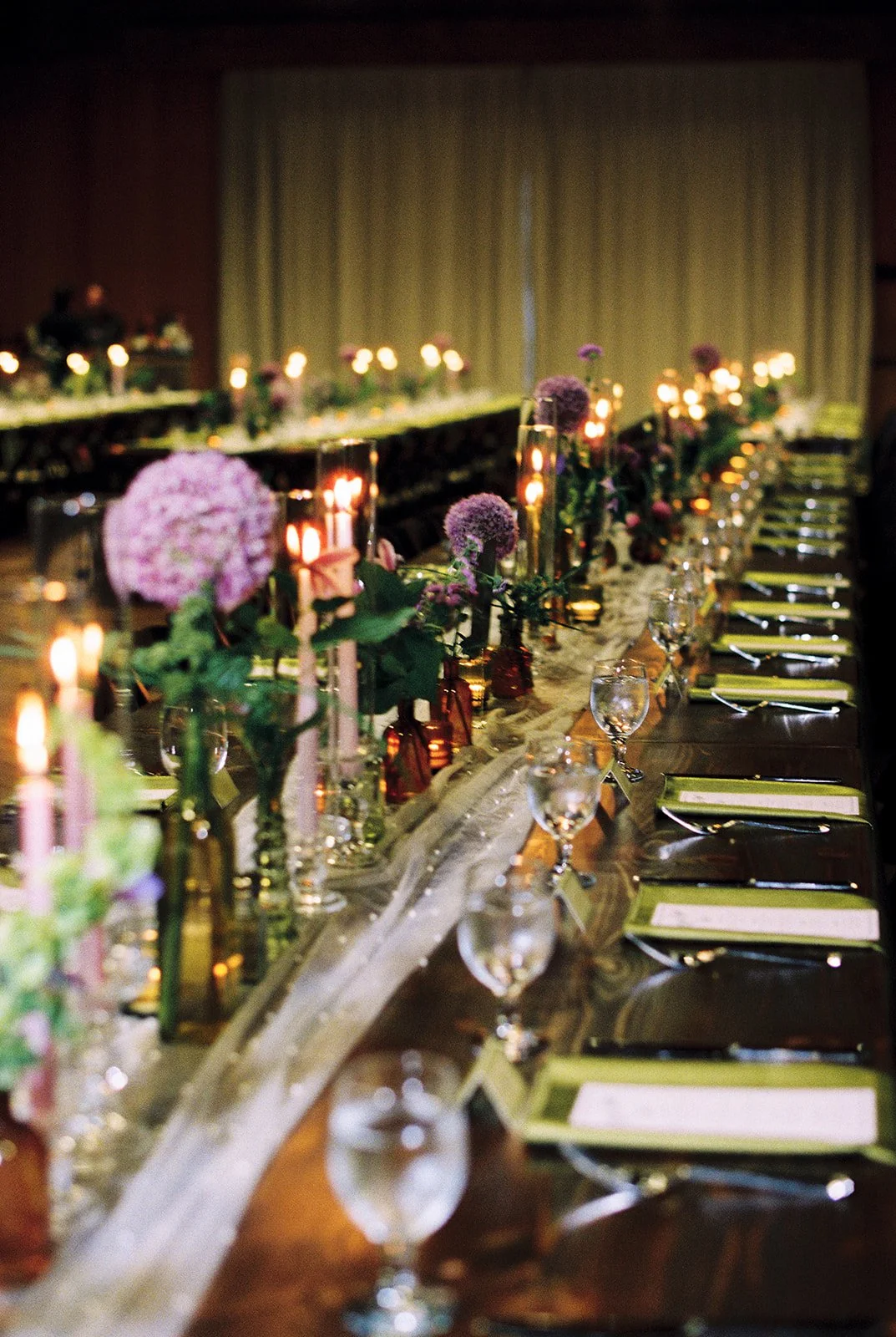 Wooden wedding table with purple and green flowers.