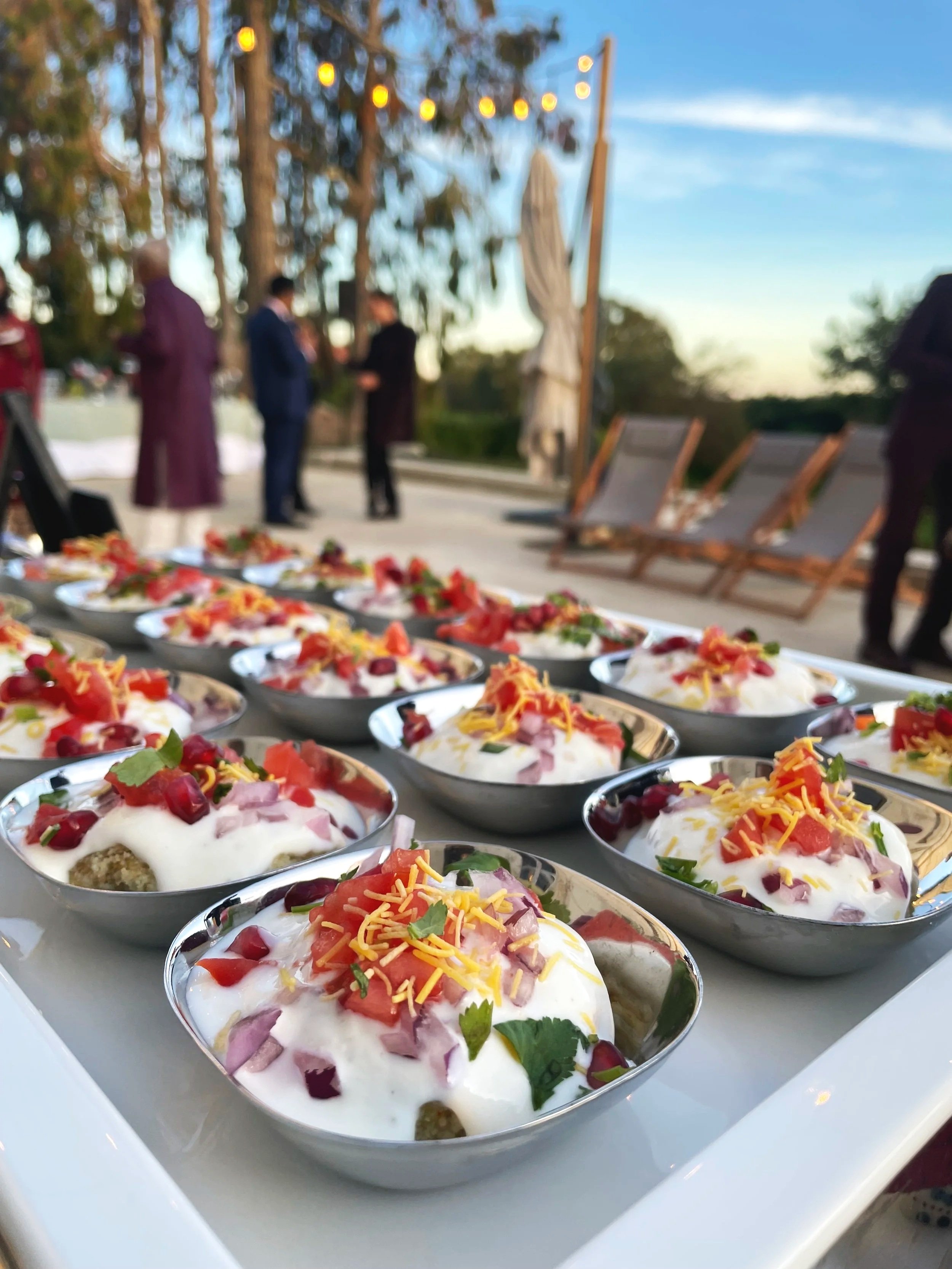 Plats servis avec des ingrédients frais comme des tomates, de la viande, des piments et des garnitures colorées.