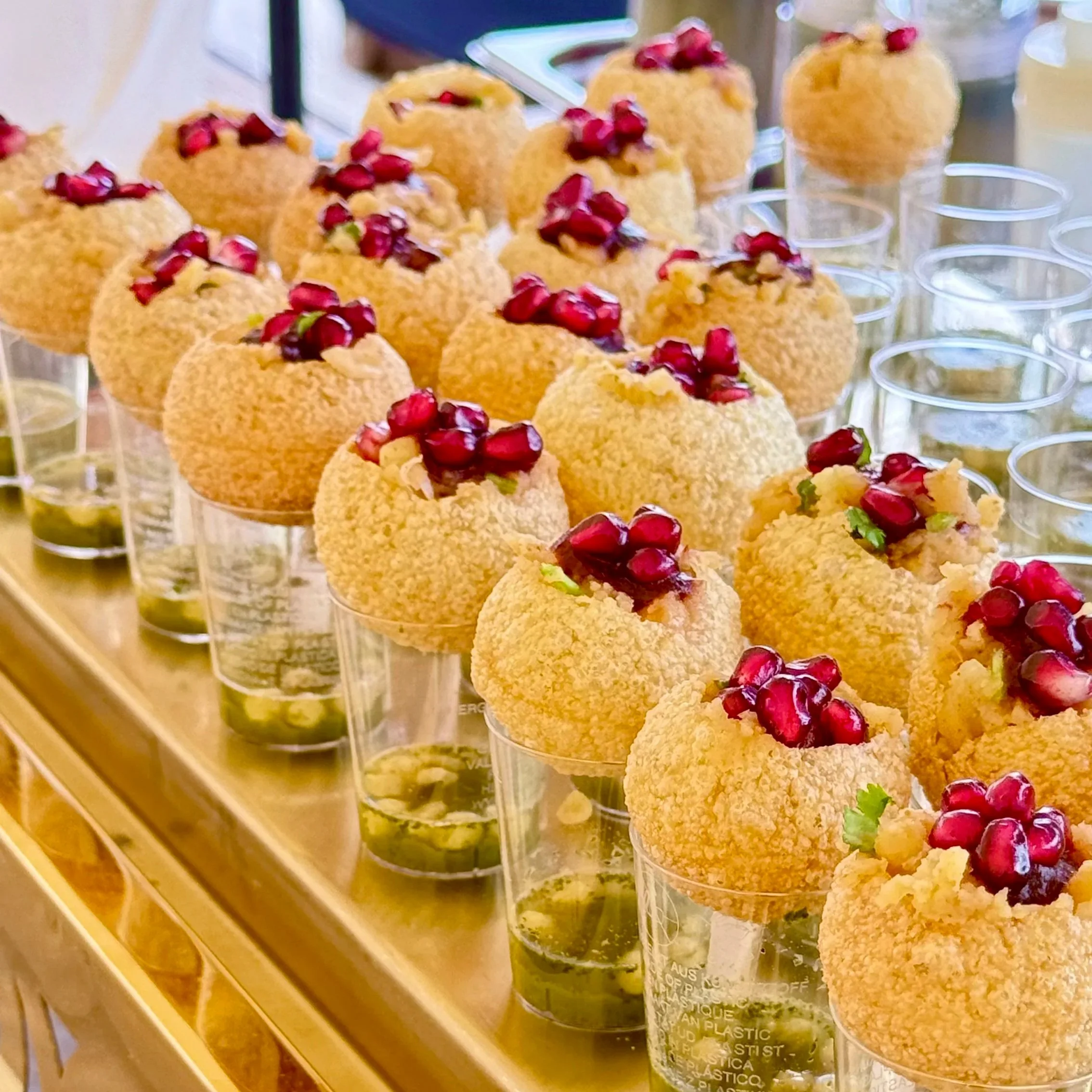 Canapés avec boulettes croustillantes, garnies de graines de grenade et de coriandre, servis dans des petits verres