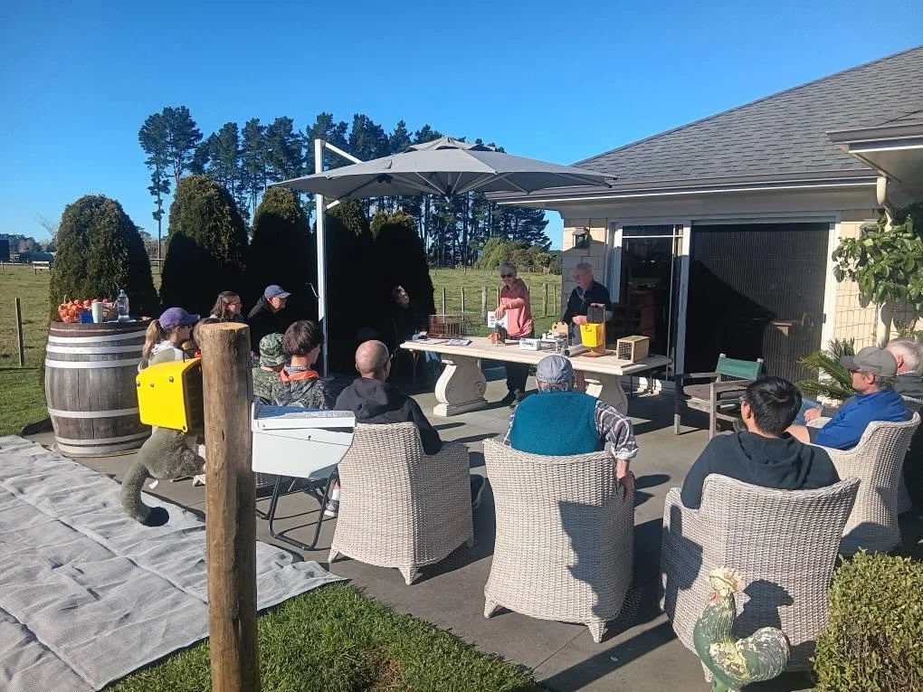 Newstead residents gathered outdoors for the launch of Predator Free Newstead, with predator traps on display.