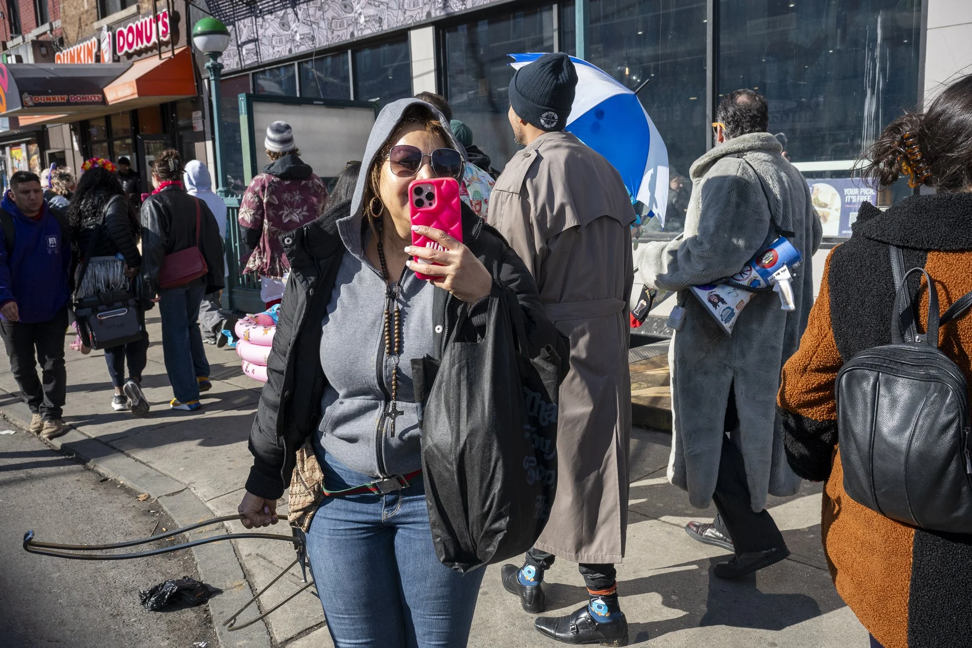 A woman records teams walking to the first checkpoint right outside the Grand St. subway station