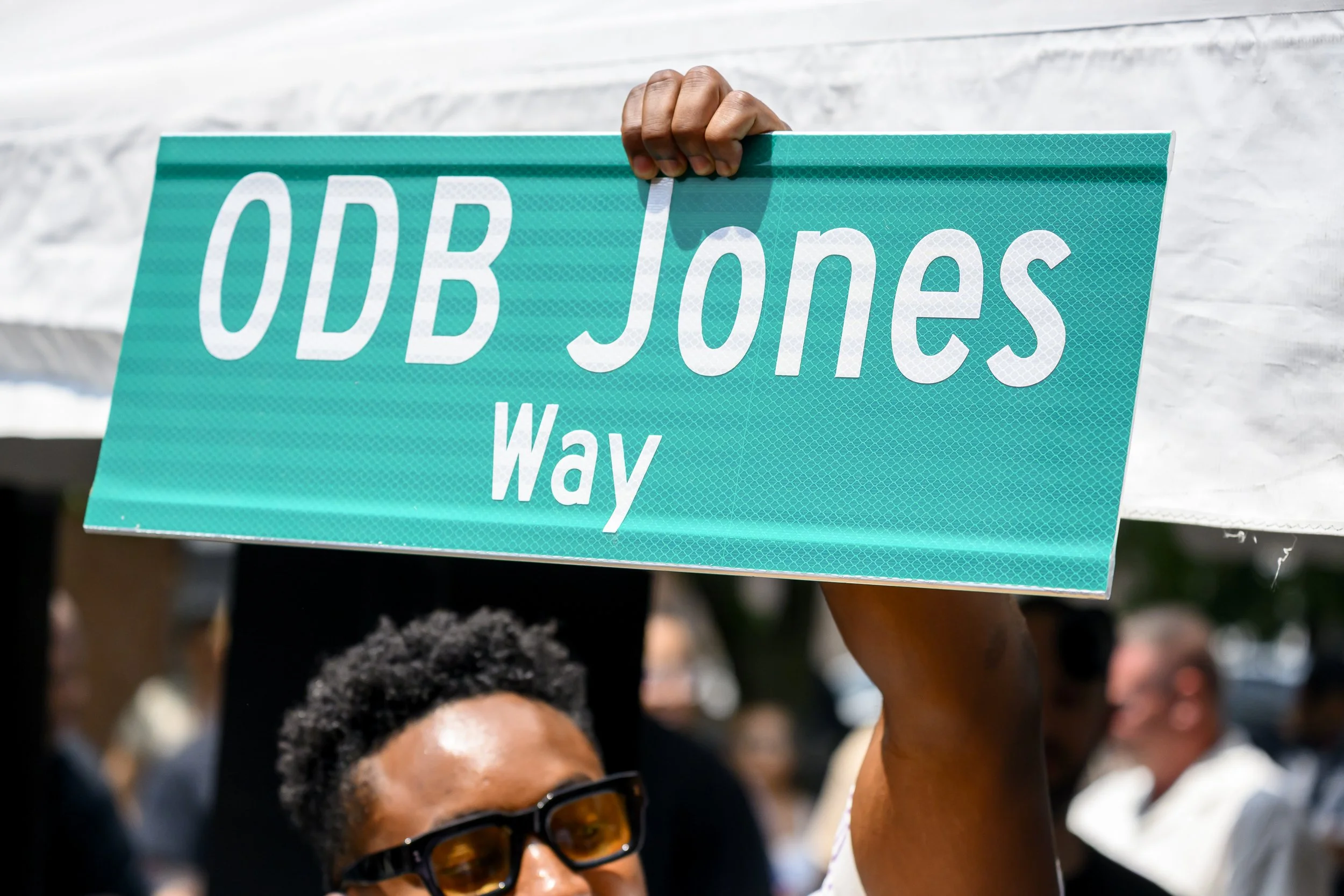 New York City Council Member Chi Ossé holds up a replica of the street sign, gifted to ODB's family