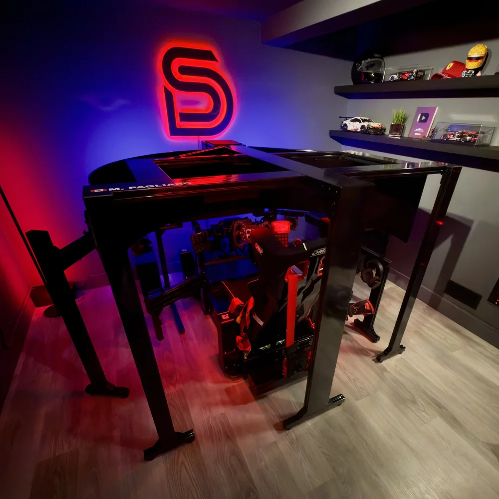 Inside The SimRacing Den, with the racing cockpit and red neon logo