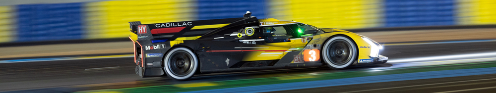 Race car speeding on a track at night with a blurred background.
