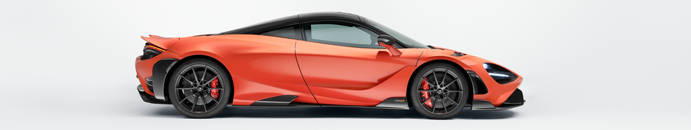 Side view of a sleek orange and black sports car with aerodynamic design.