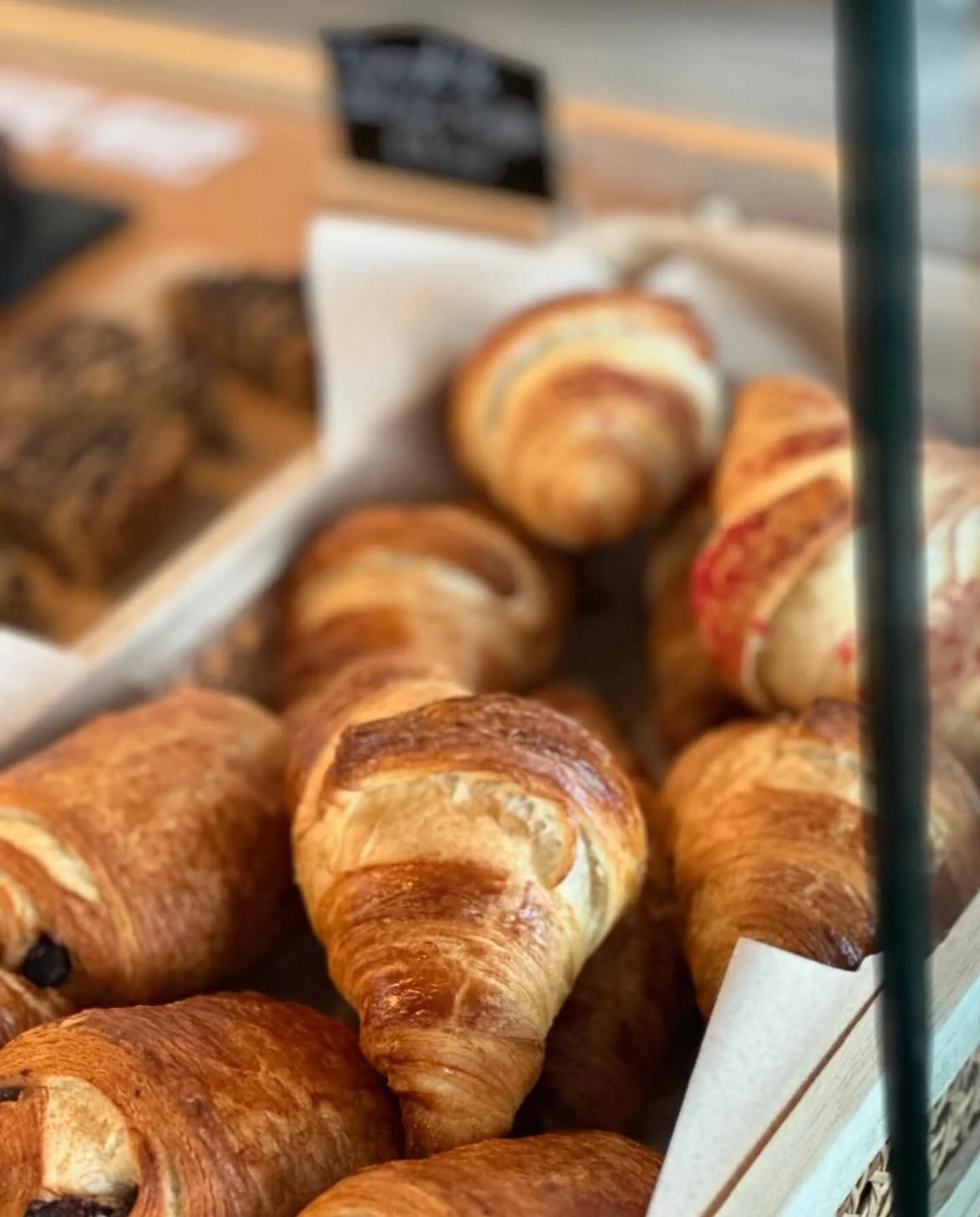 An arty shot of a basket of freshly cooked all butter croissants