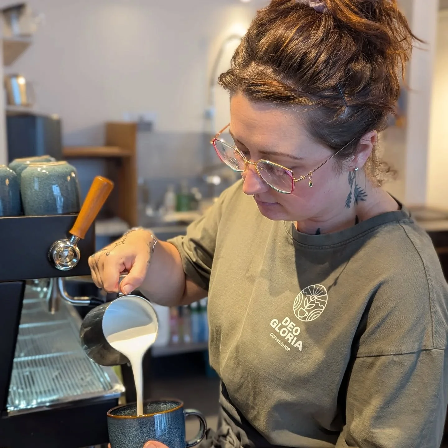 A barista skillfully pouring warmed milk into a cup