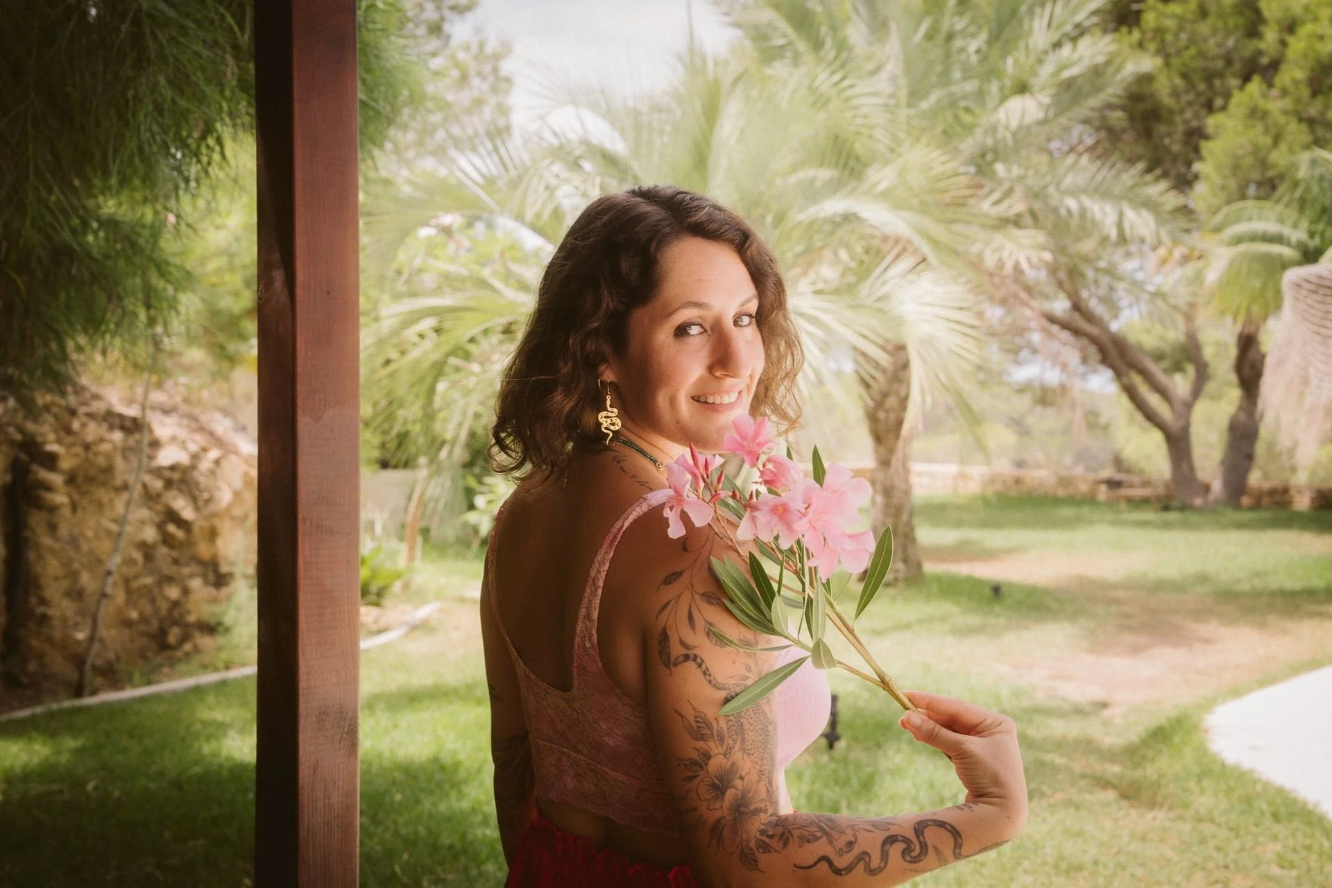 Woman invites you on journey with flowers in her hand during a transformational journey with guide and mentor, Aoise, iamaoise