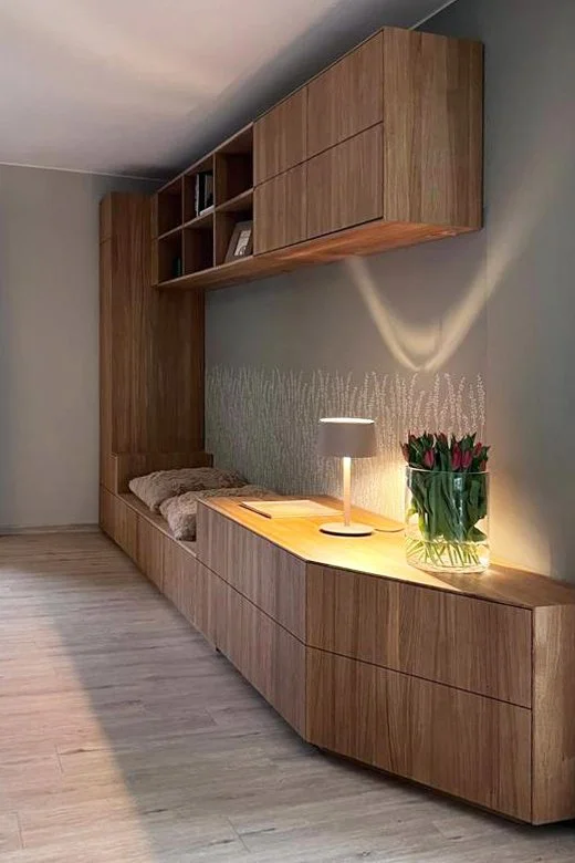 Schrankwand mit Sitzbank und viel Stauraummöglichkeiten in einem Wohnhaus.