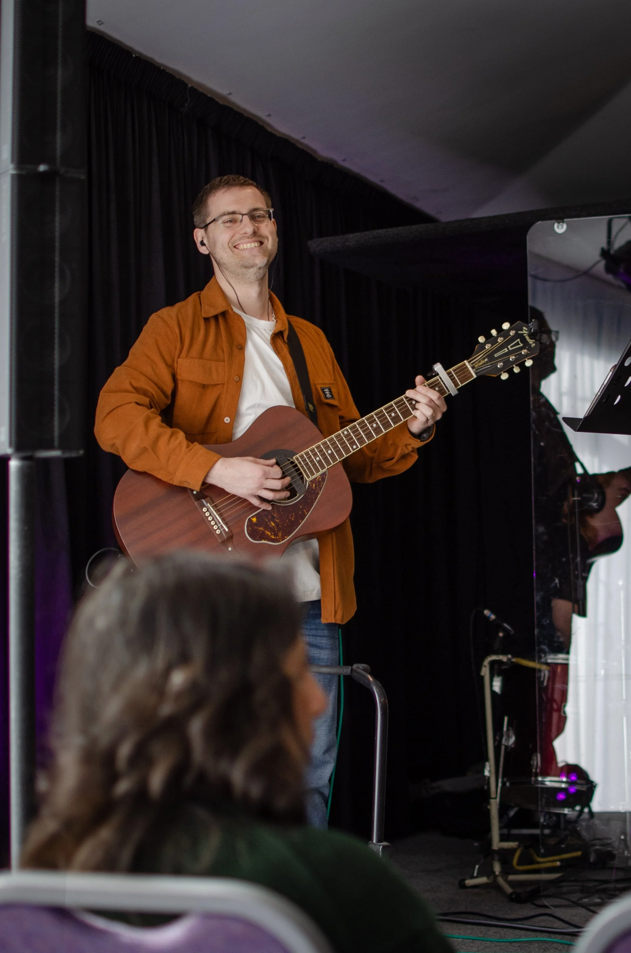 A man holding a guitar and smiling