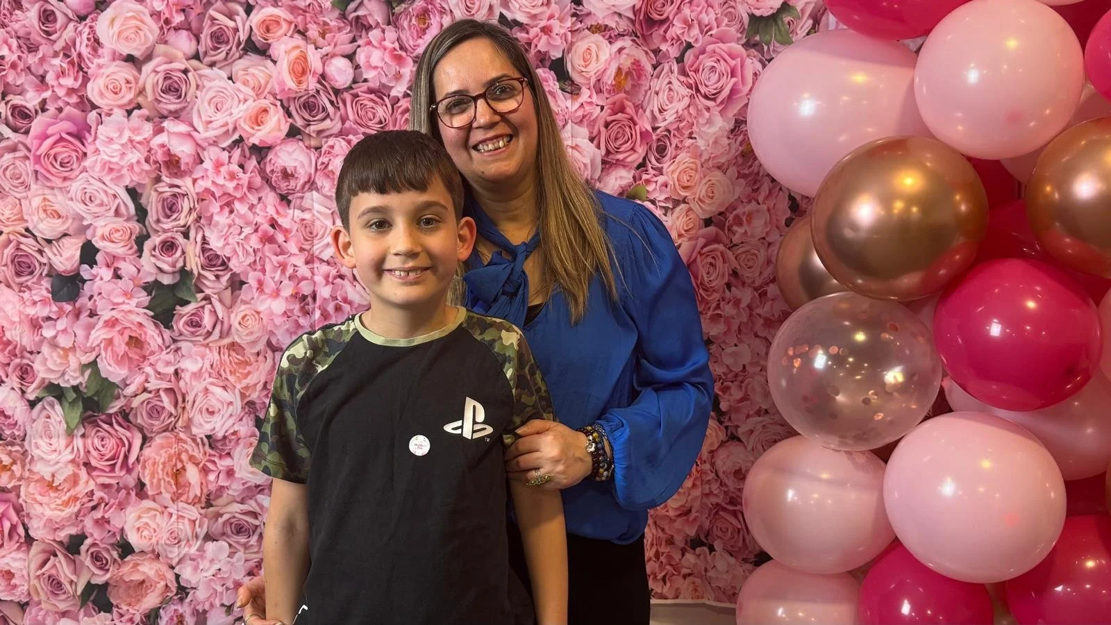 A mother and son in front of a photobooth