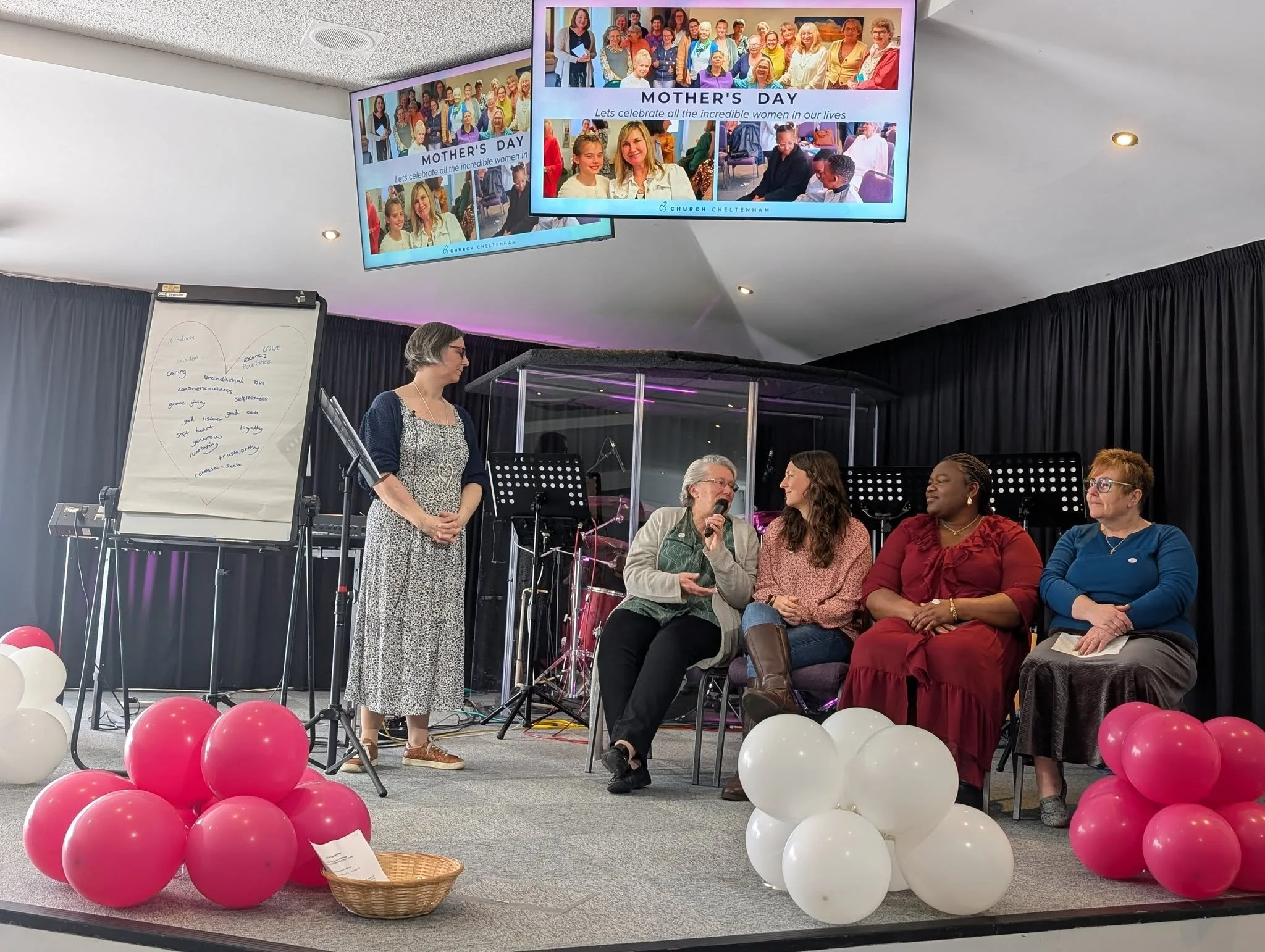 A line of older and younger women talking on stage