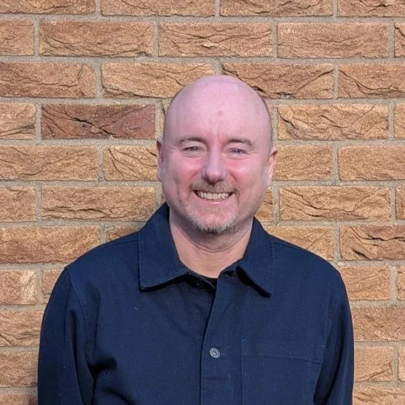 Man smiling in blue shirt