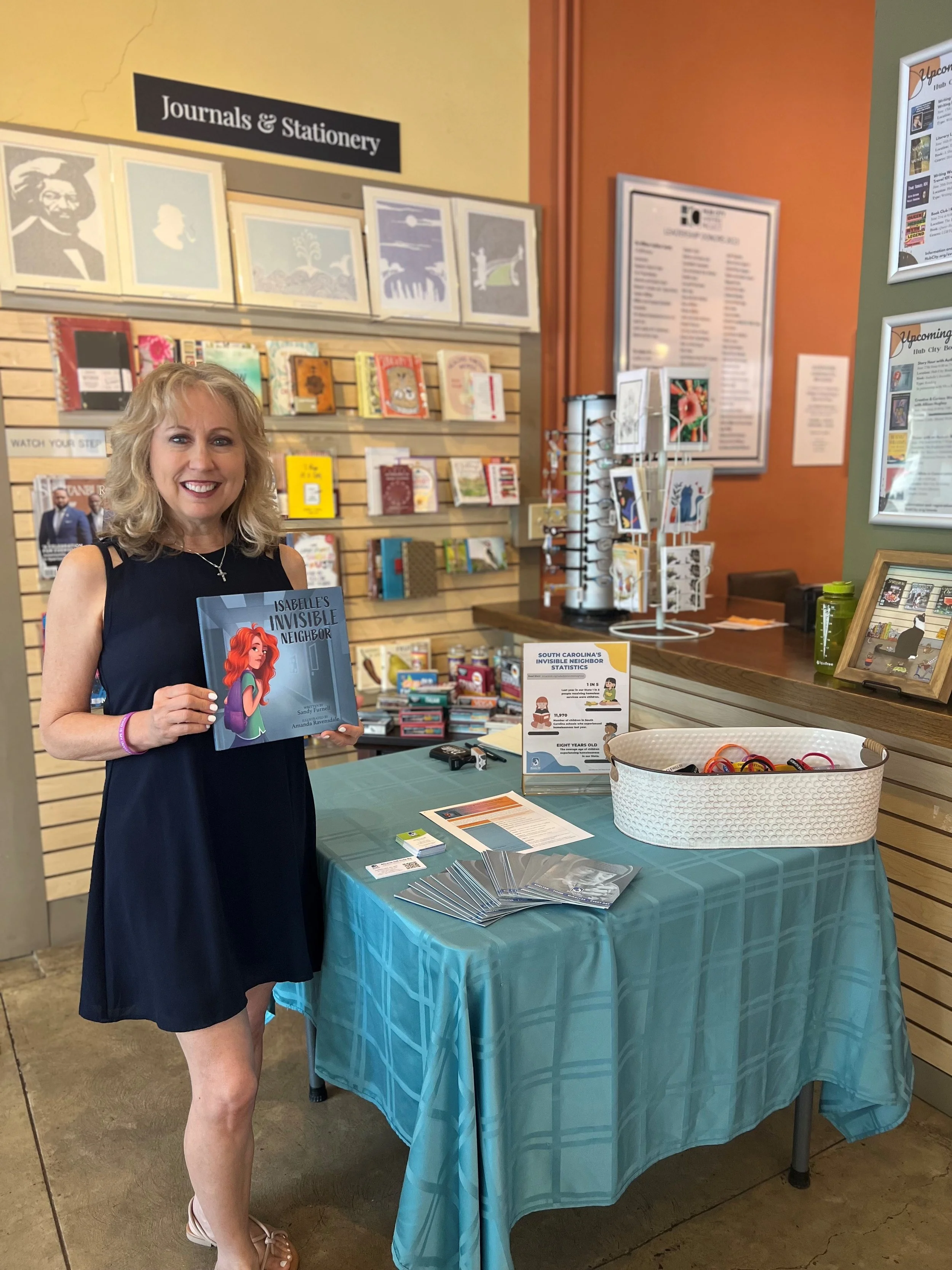 Sandy Furnell holding Isabelle's Invisible Neighbor book at Hub City Bookshop
