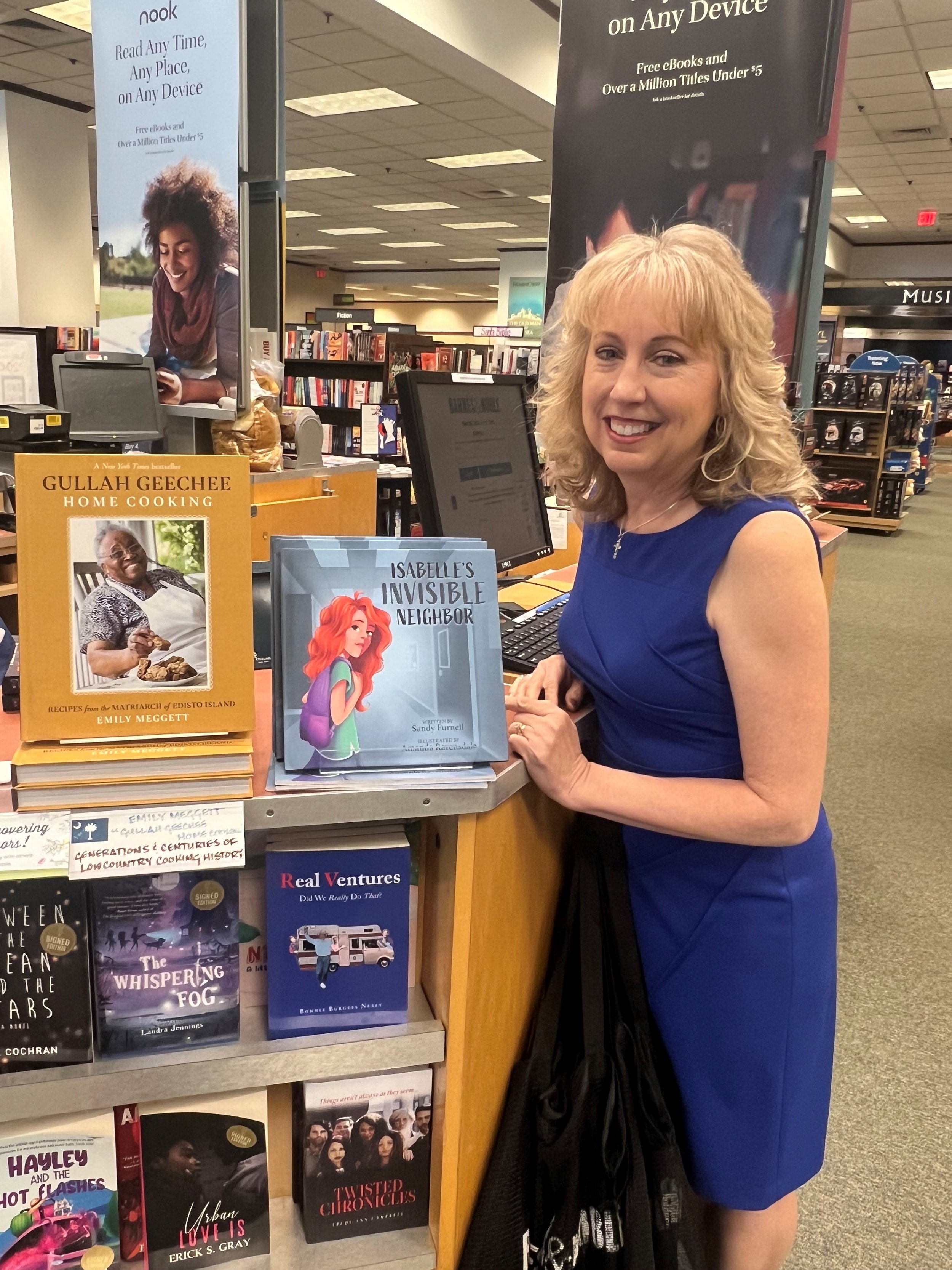 Sandy Furnell next to Isabelle's Invisible Neighbor book display at Barnes & Noble