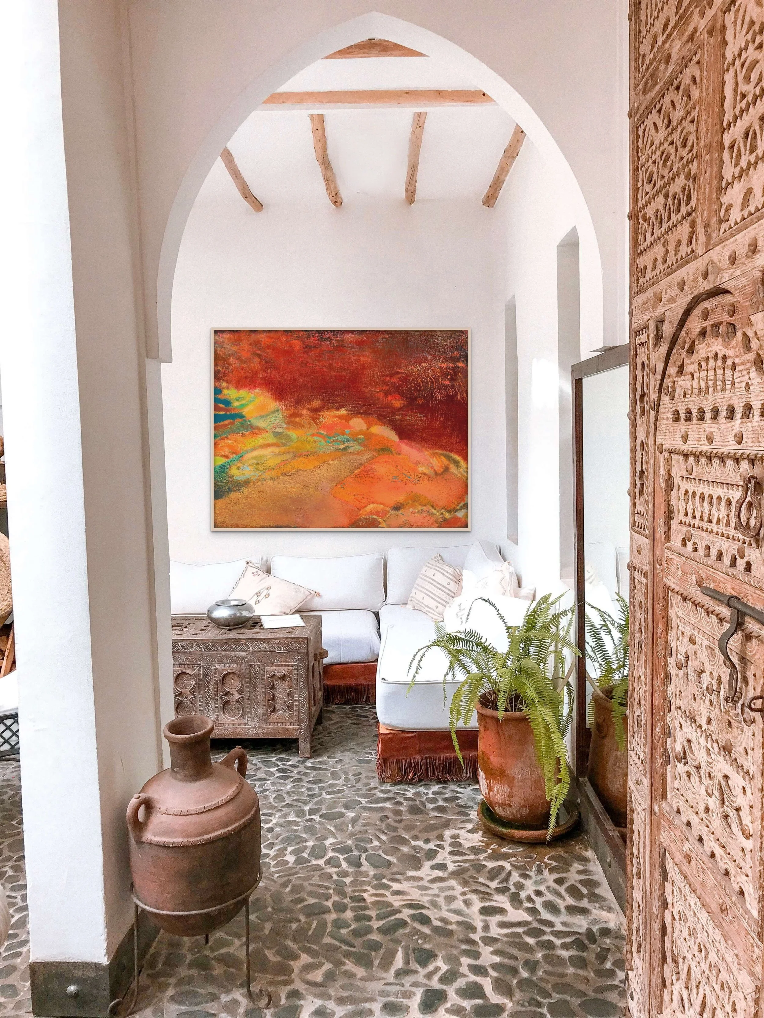 Original large landscape painting for sale in red and orange tones, in an arched living space with terracotta detailing