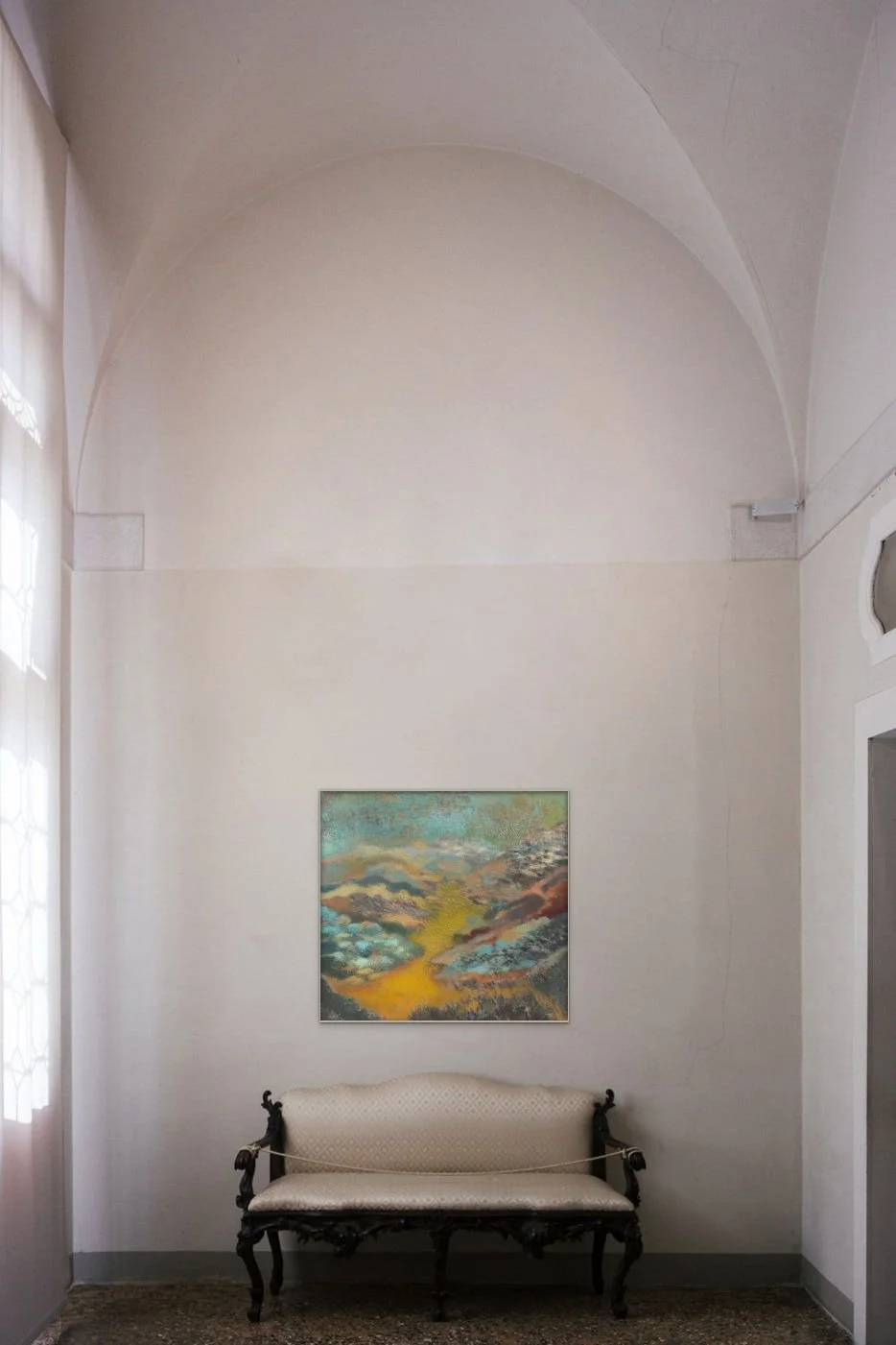 Original landscape painting for sale in teal and gold tones, installed in a living room