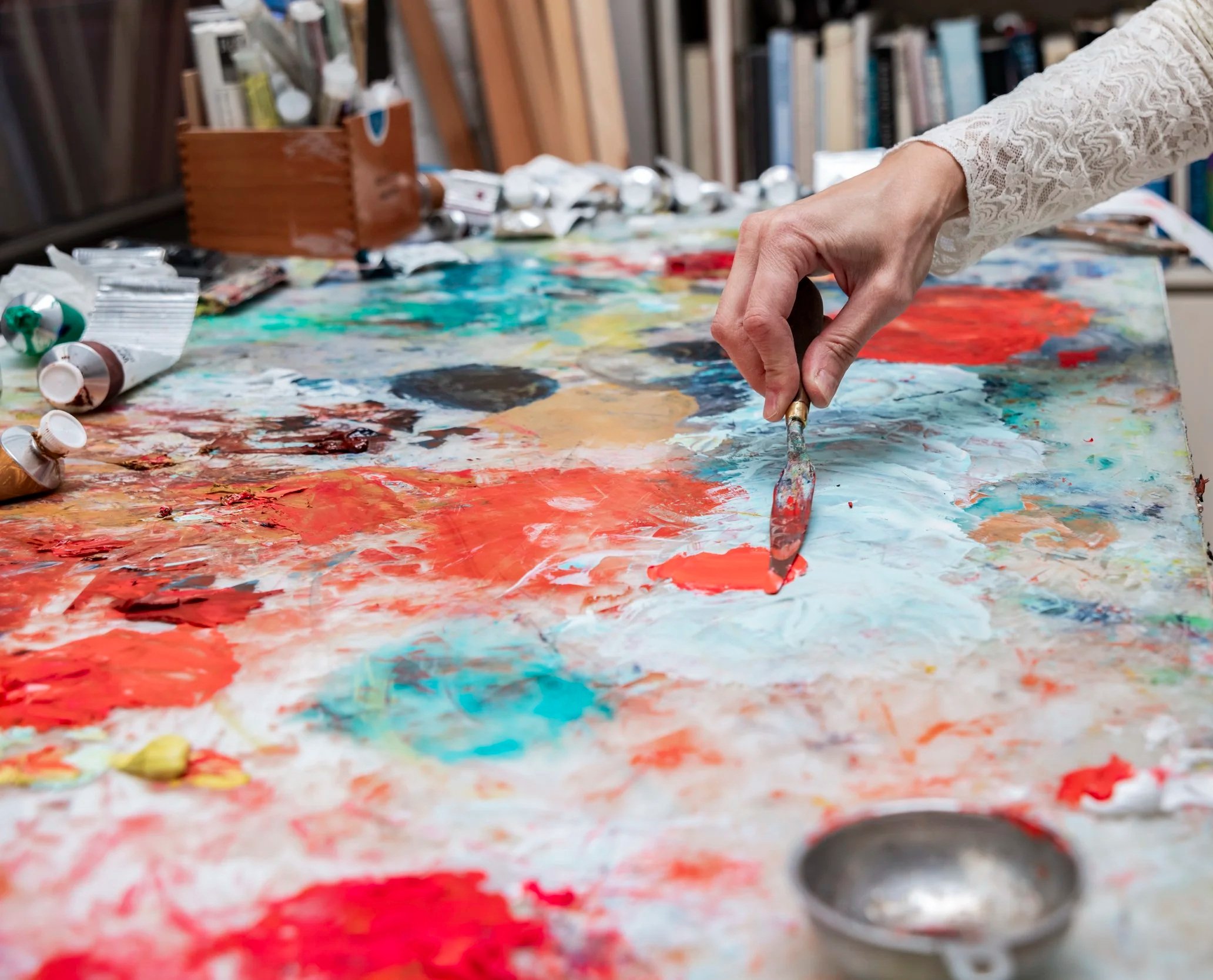 Close-up of a painter's hand mixing colors on her palette in her NYC studio.