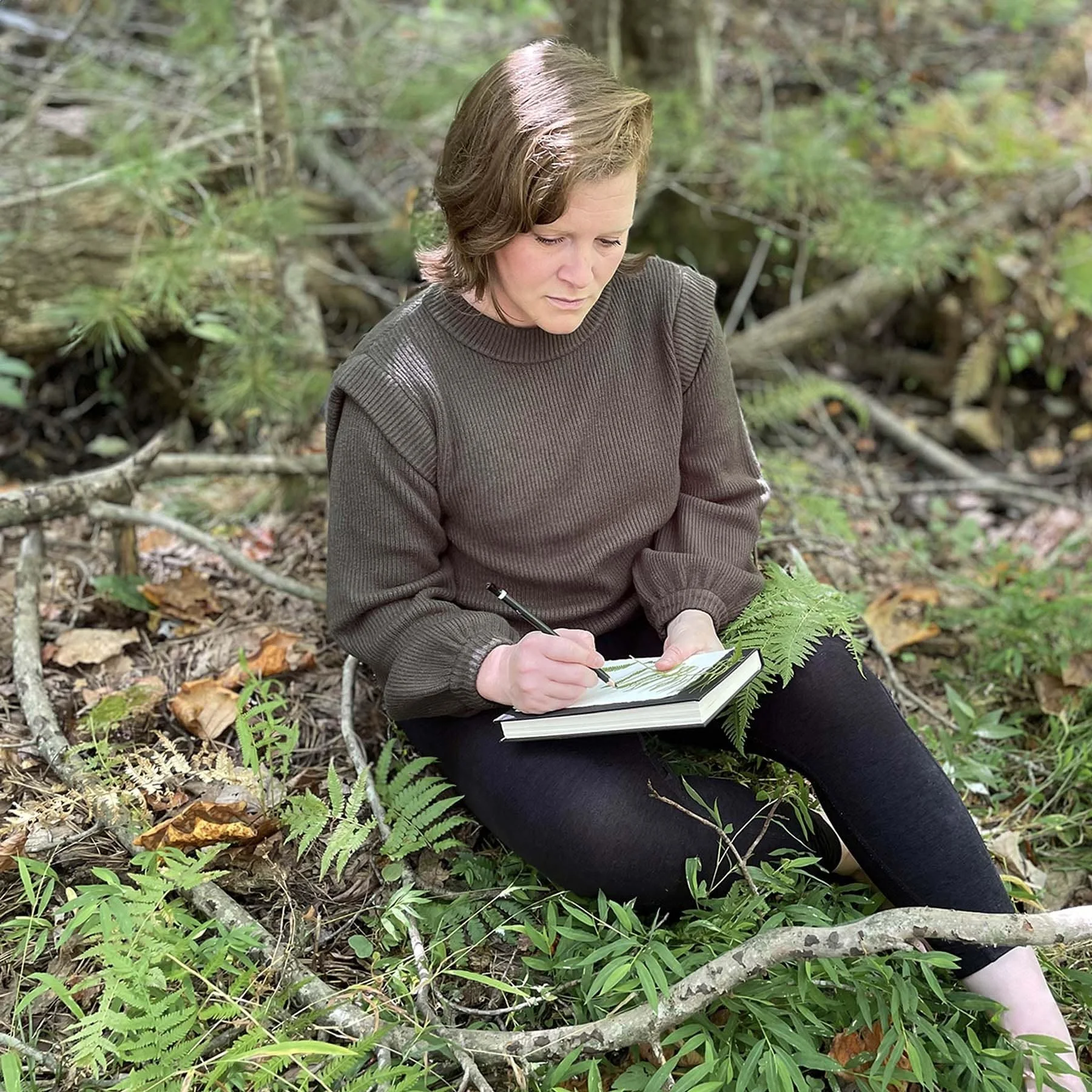 Asheville artist and textile designer Amy Warr drawing ferns in the woods of Western North Carolina
