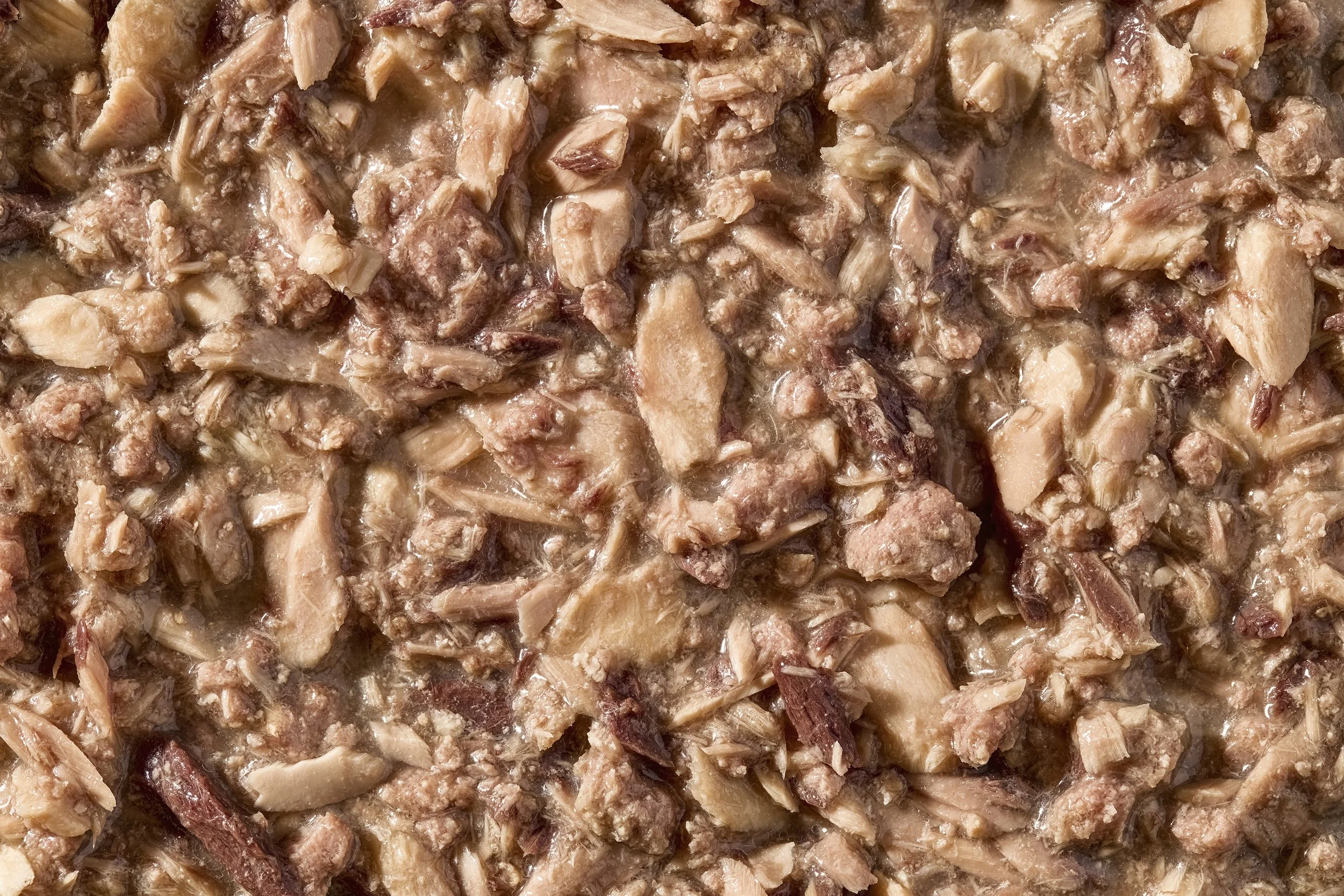 Close-up of cooked shredded meat in a pan.