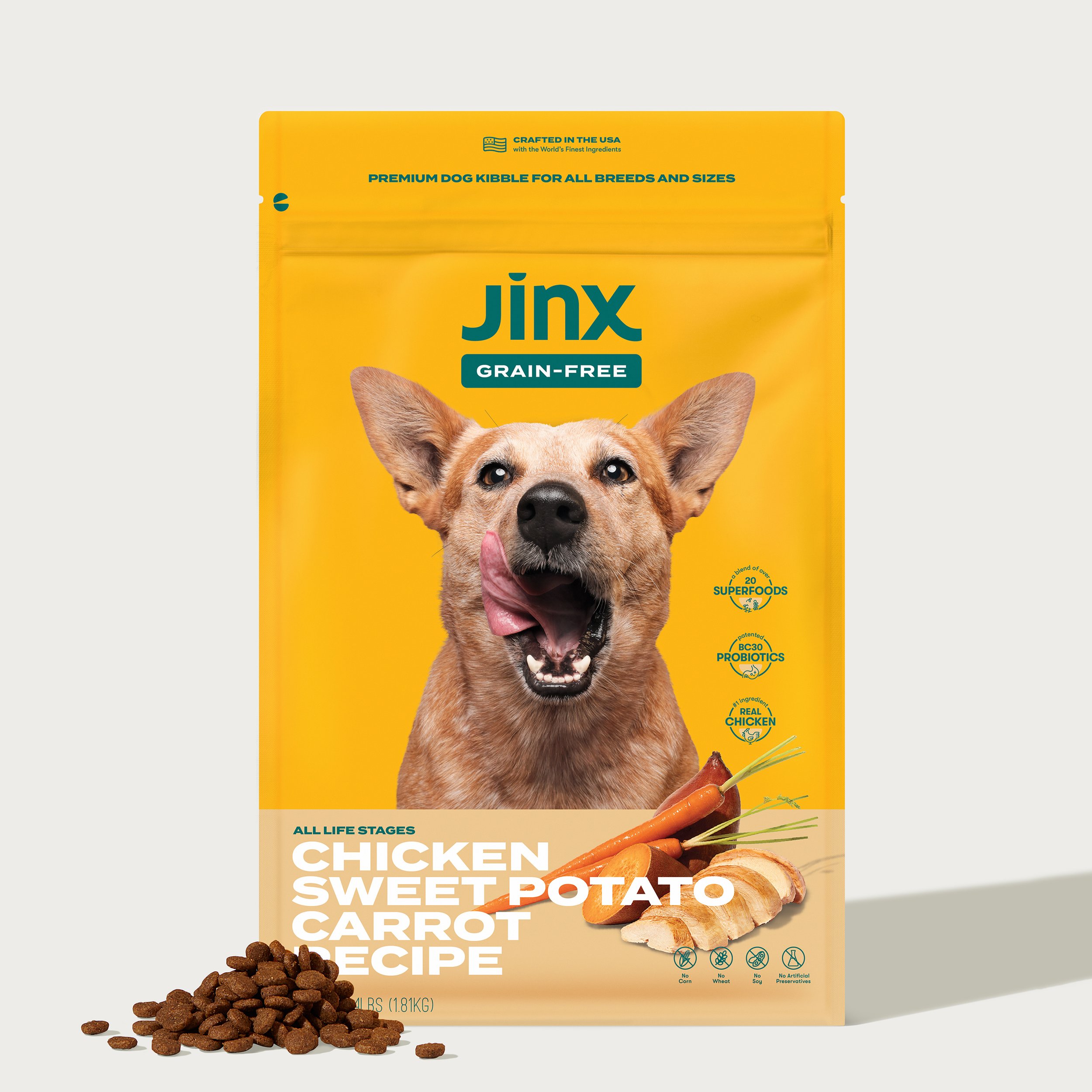Yellow bag of Jinx grain-free dog food featuring chicken, sweet potato, and carrot recipe with dog image and kibble on the side.