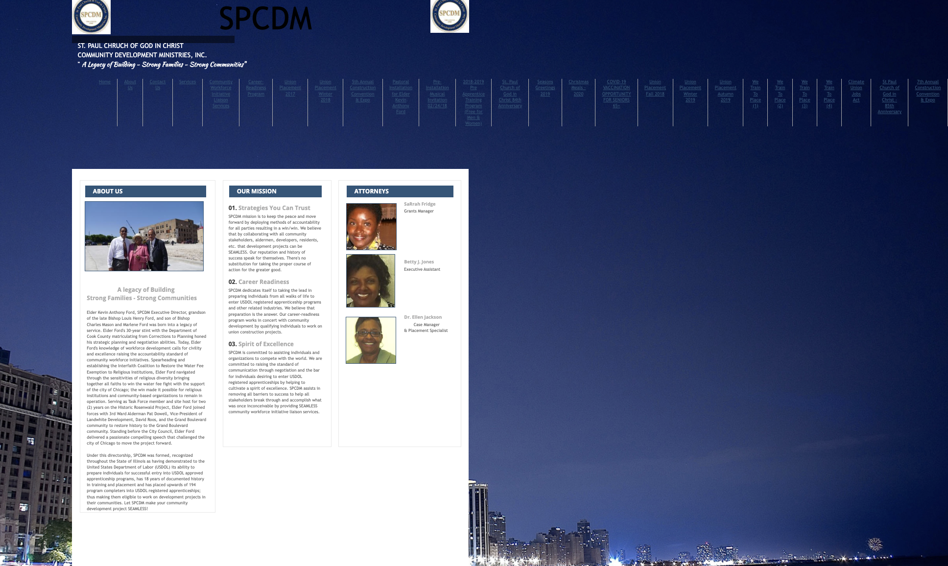 A webpage with text about SPCDM, photos of people, and a cityscape background with a dark blue sky.