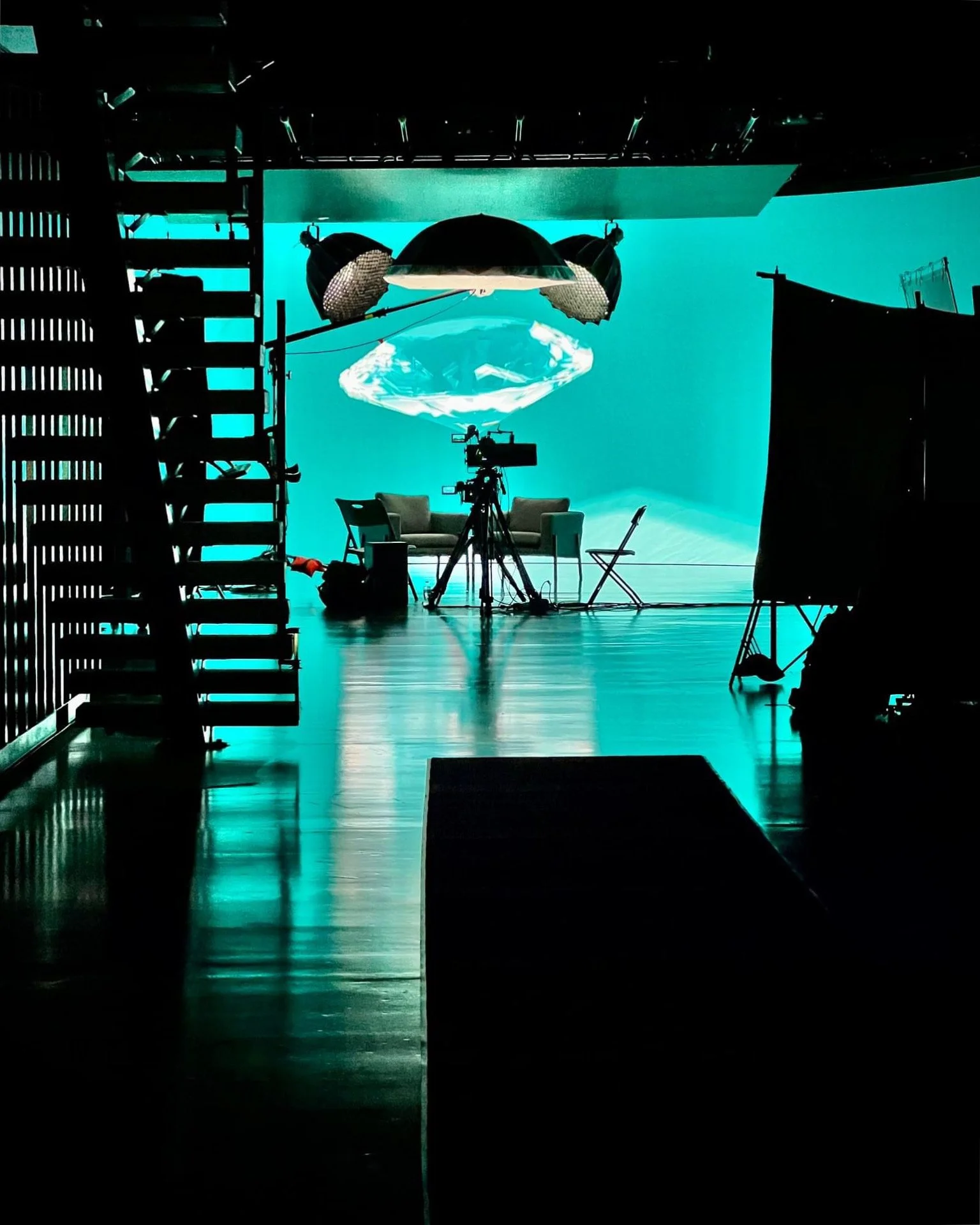 Behind-the-scenes photo of IDEOLOGY's Golden Hour studio featuring a bright LED screen, dark ambient lighting, and professional camera equipment.