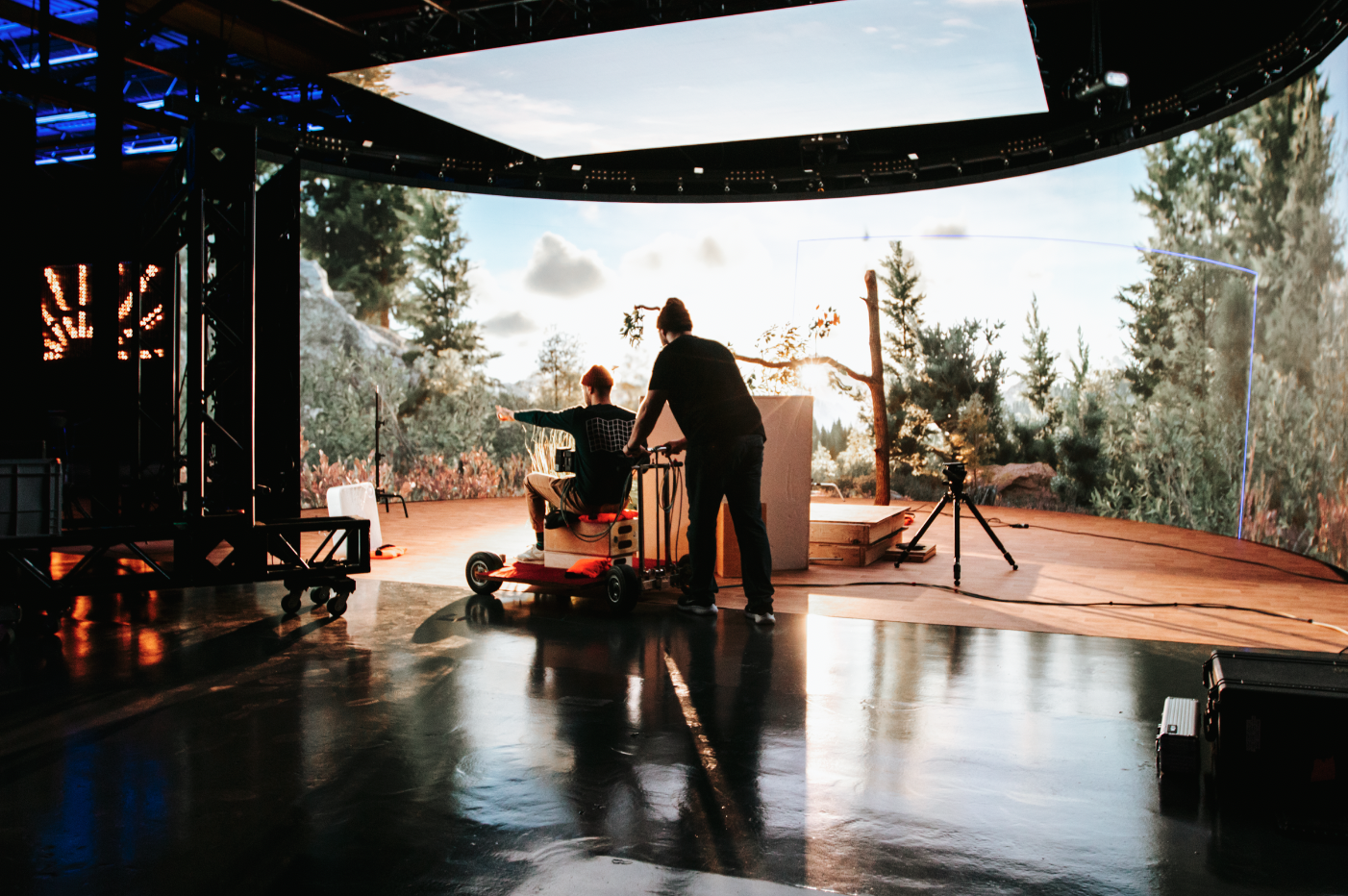 Two people on set in Golden Hour’s studio in front of a state-of-the-art virtual production screen displaying a digital environment.