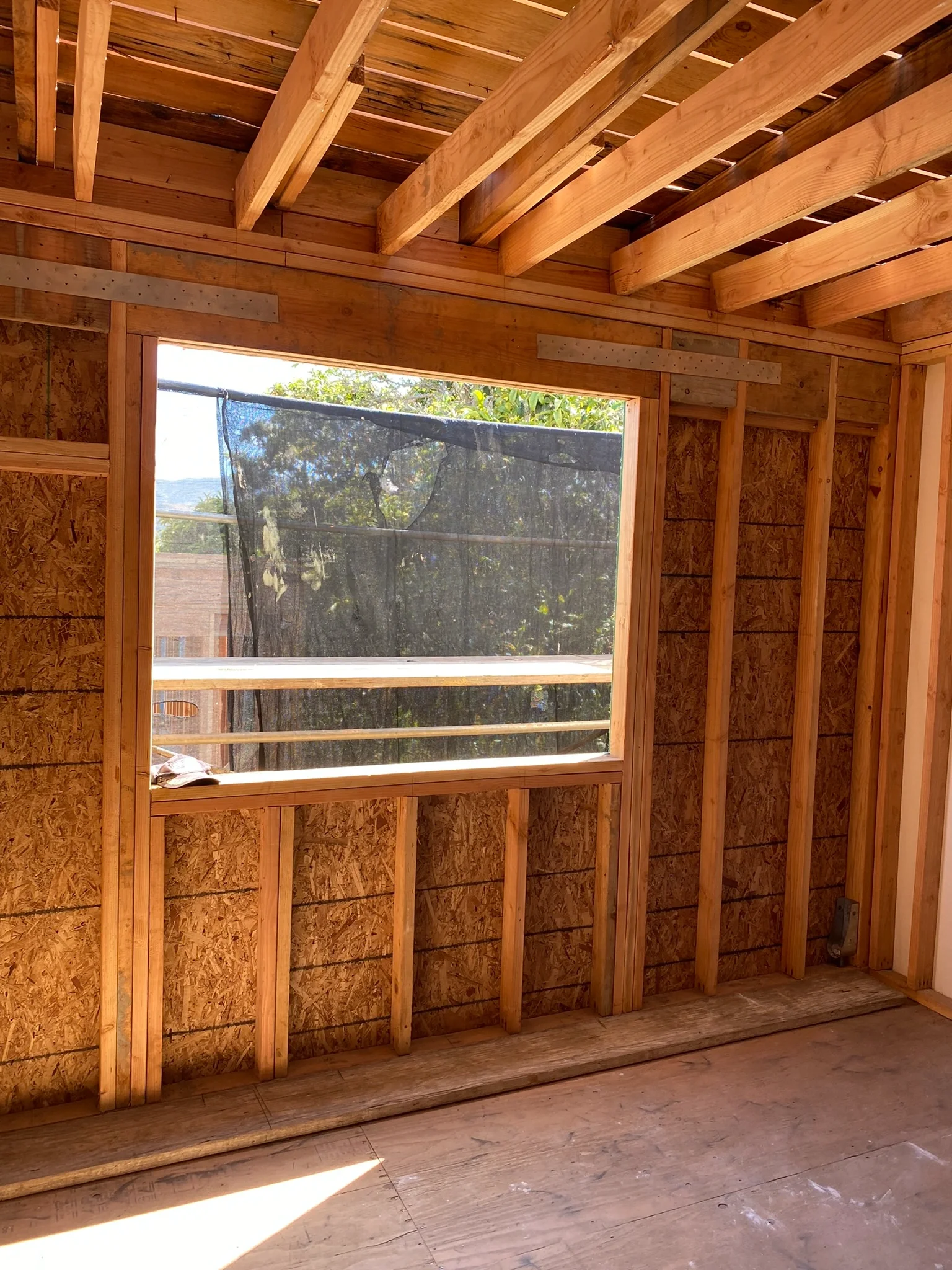Detached ADU framing with large window rough opening and structural studs — San Francisco Bay Area general contractor