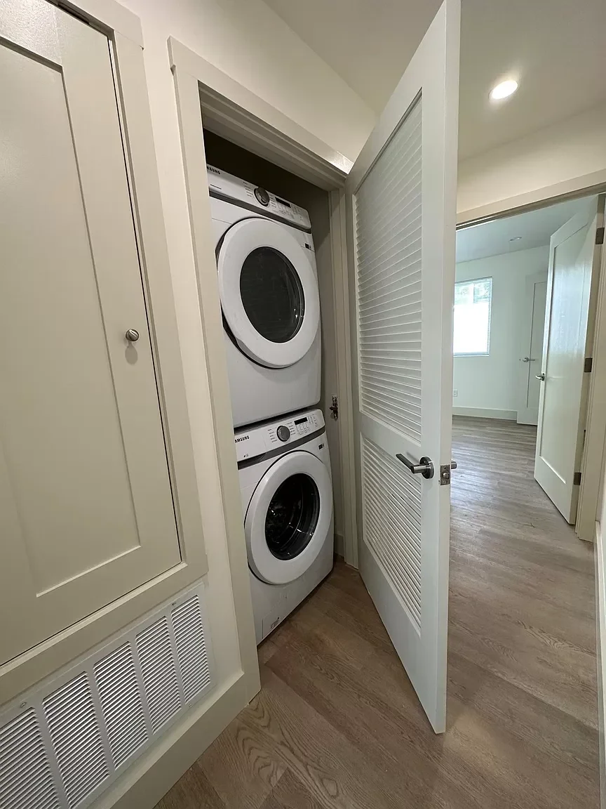 Stacked washer and dryer in detached ADU utility closet with built-in shelving — San Francisco Bay Area general contractor