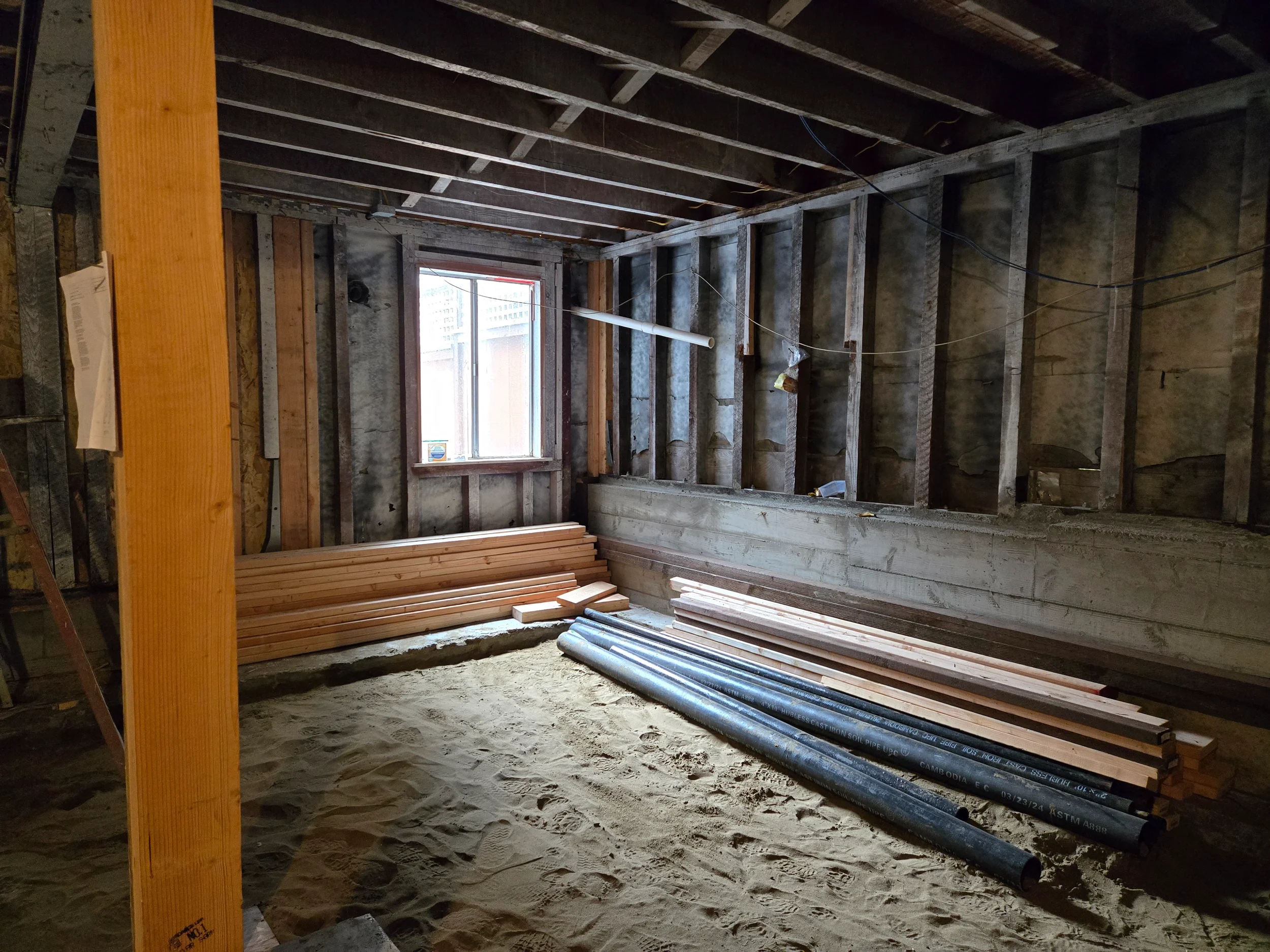 Underfloor insulation and subfloor prep in progress for ground-floor conversion — San Francisco Bay Area general contractor