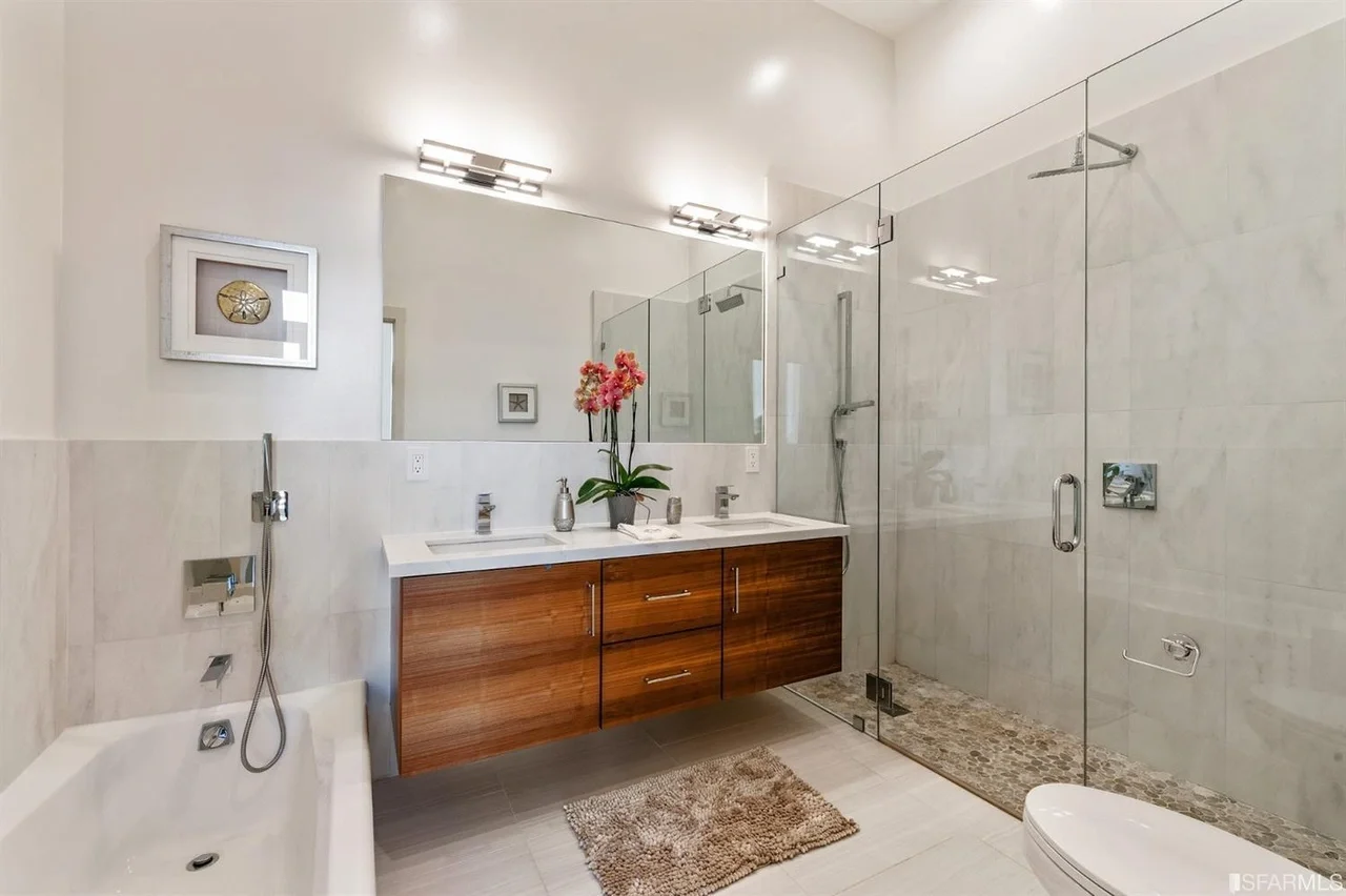 Primary bathroom in home addition with glass shower and wood vanity — San Francisco Bay Area general contractor