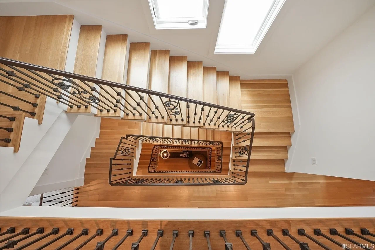 Modern open-riser staircase with wood treads and black metal railing — San Francisco Bay Area general contractor