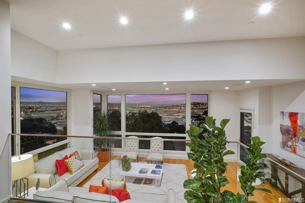 Dusk living room in single-family home addition with large picture windows and city view — San Francisco Bay Area general contractor