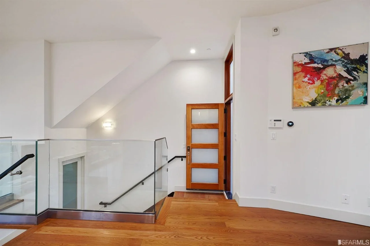 Interior stair landing in vertical addition with modern railing and hardwood floors — San Francisco Bay Area general contractor