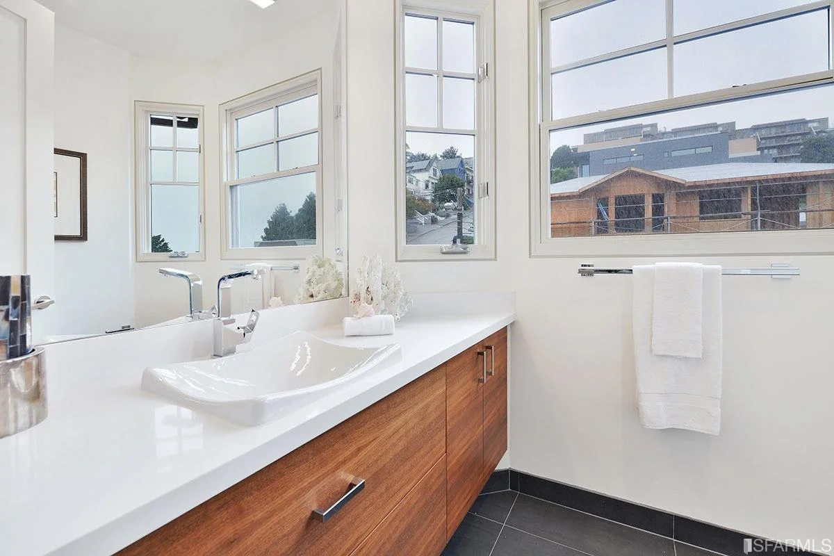 Bathroom vanity upgrade with wood cabinetry, double sinks, and large mirror — San Francisco Bay Area general contractor