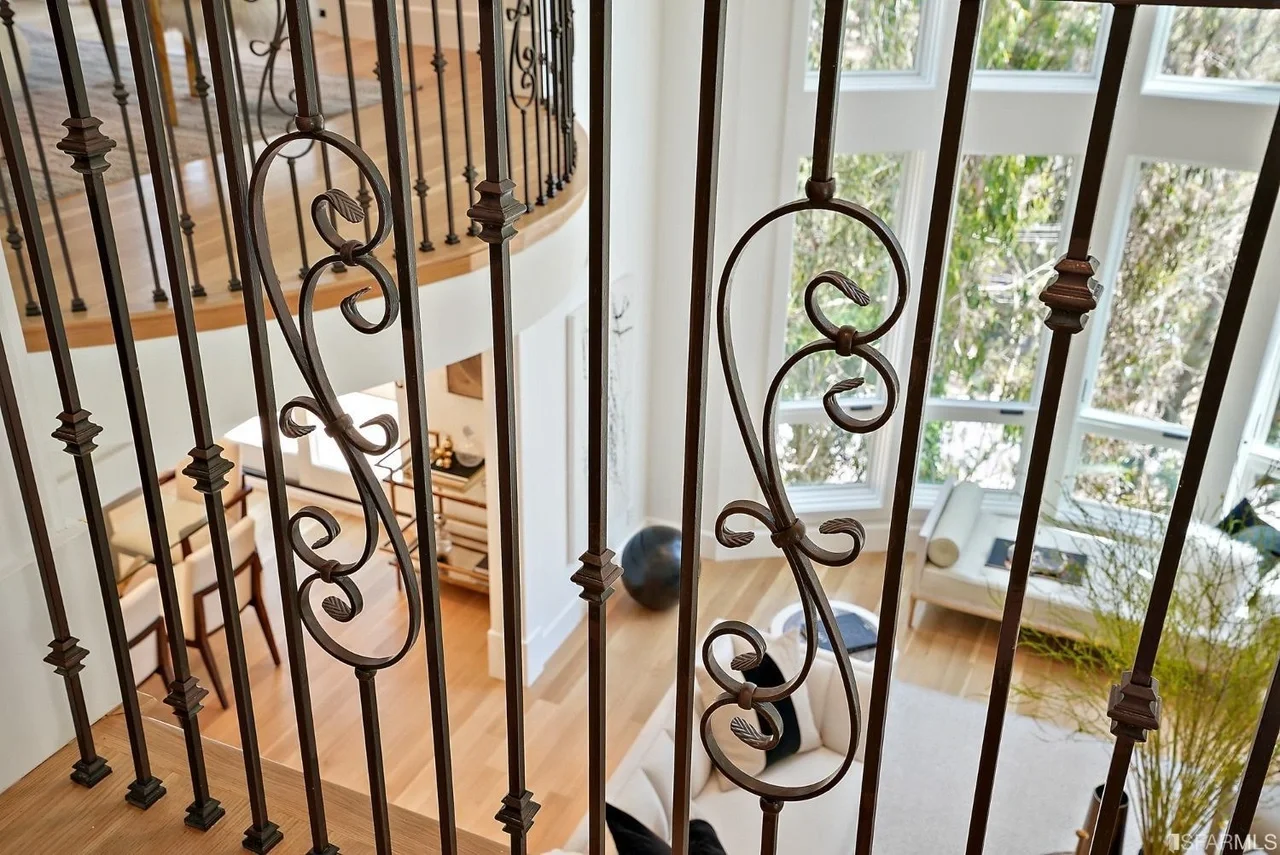 Decorative iron stair railing detail on remodeled staircase — San Francisco Bay Area general contractor.