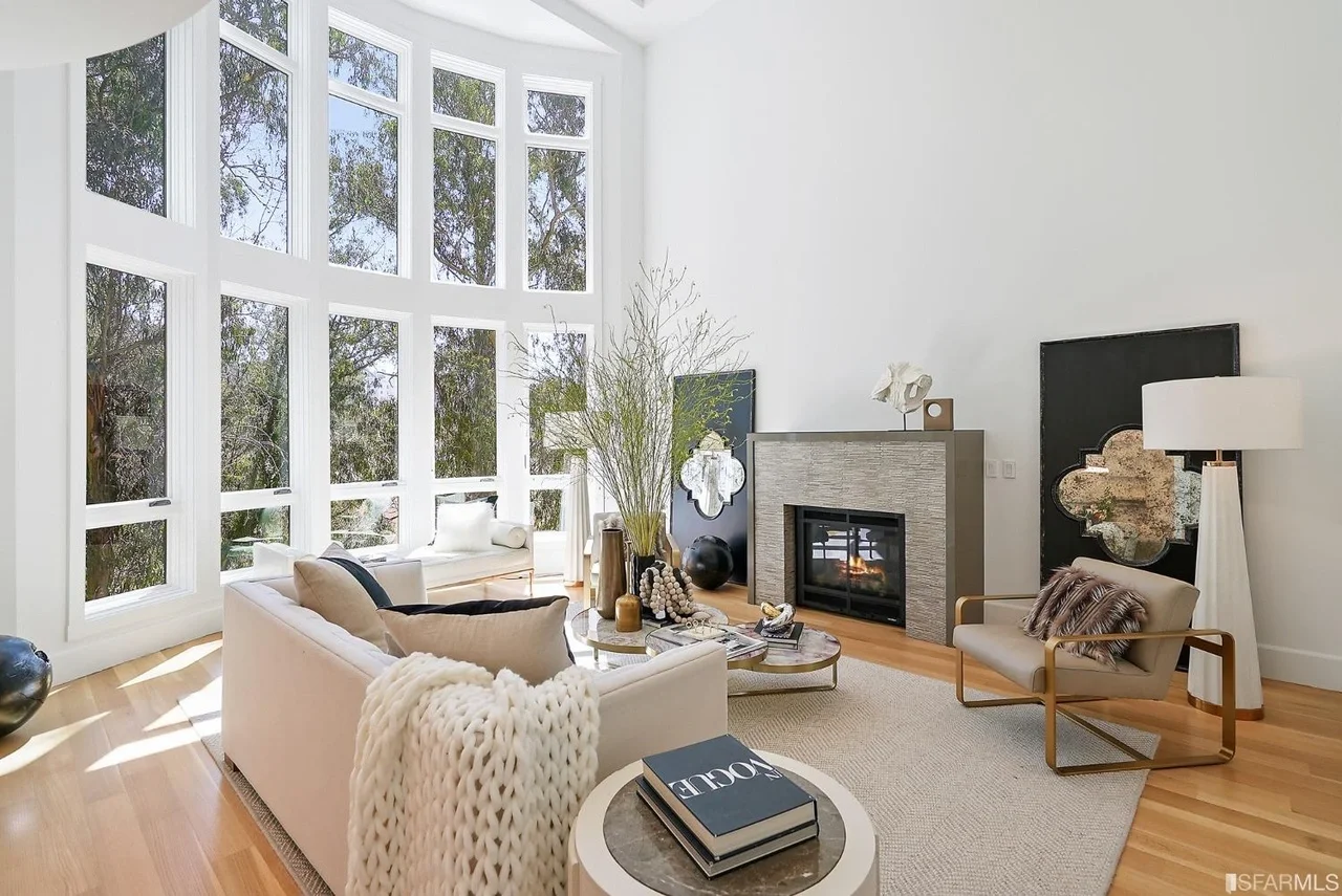 Double-height living room renovation with floor-to-ceiling windows, modern fireplace, and wide-plank hardwood flooring—San Francisco Bay Area general contractor, Pinnacle Construction.